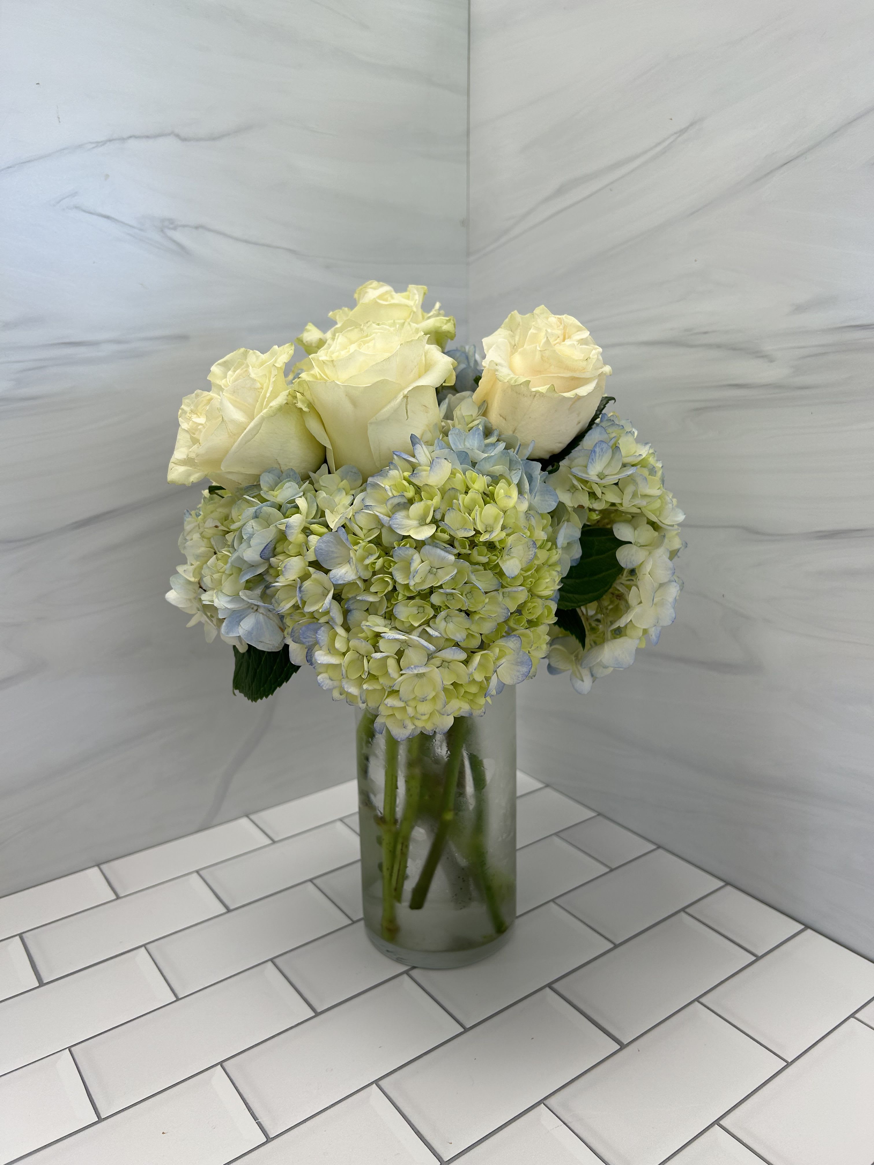 Simply Mom - A simple and elegant way to say Happy Mother's Day with this bouquet.  Stunning blue hydrangea and white roses in a simple vase.  Bouquet will be delivered approximately as pictured.