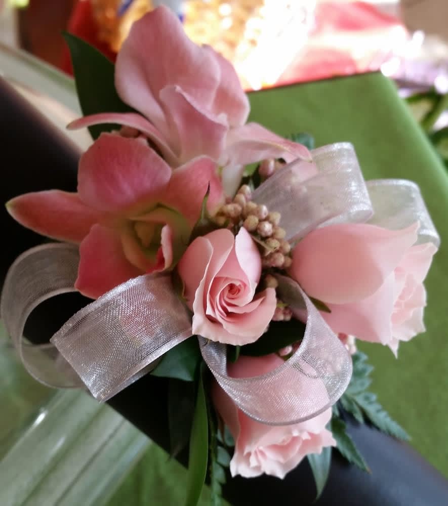 Cotton Candy Corsage - Blush pink spray roses and pink dendrobium orchid blossoms grace a petite bed of greenery, ribbon and pink accents for a purely feminine appearance.   PLEASE CALL THE SHOP AT (617)244-4422 FOR ALL CORSAGE OR BOUTONNIERE ORDERS. THANK YOU.