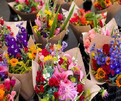 Assorted colorful bouquets wrapped in brown paper