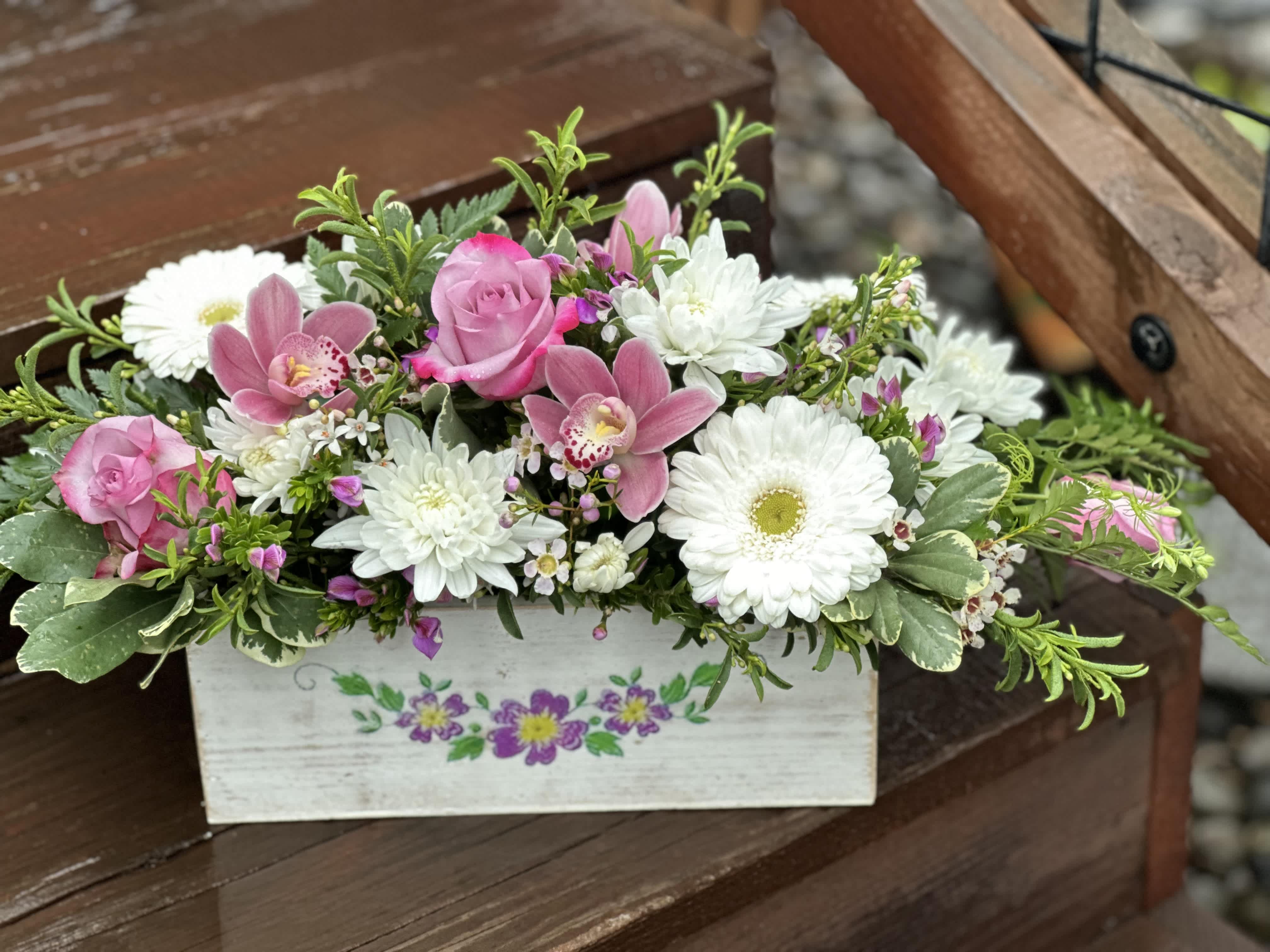 Center of Spring  - A decorative spring box filled with roses, Gerbera daisies, &amp; chrysanthemums. Suitable for a table piece. Deluxe and premium include orchids.
