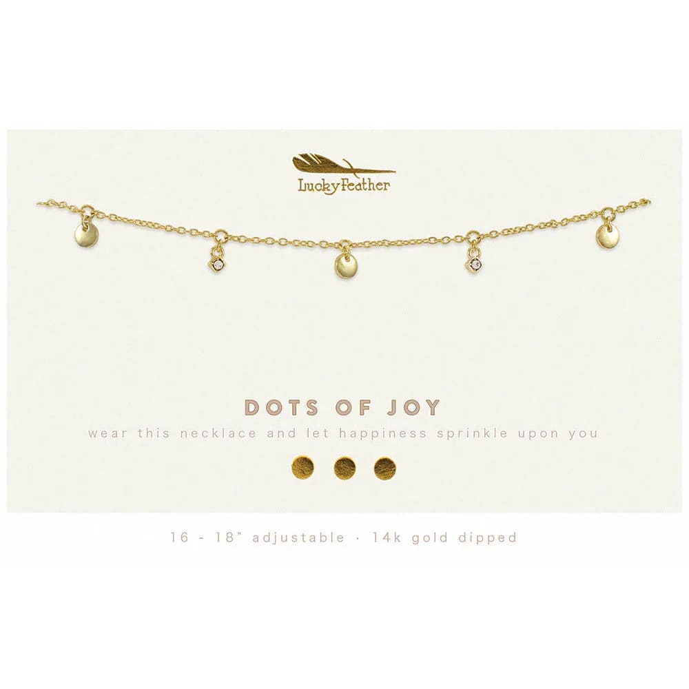 Gold charm necklace with small discs and crystal accents on a branded display card