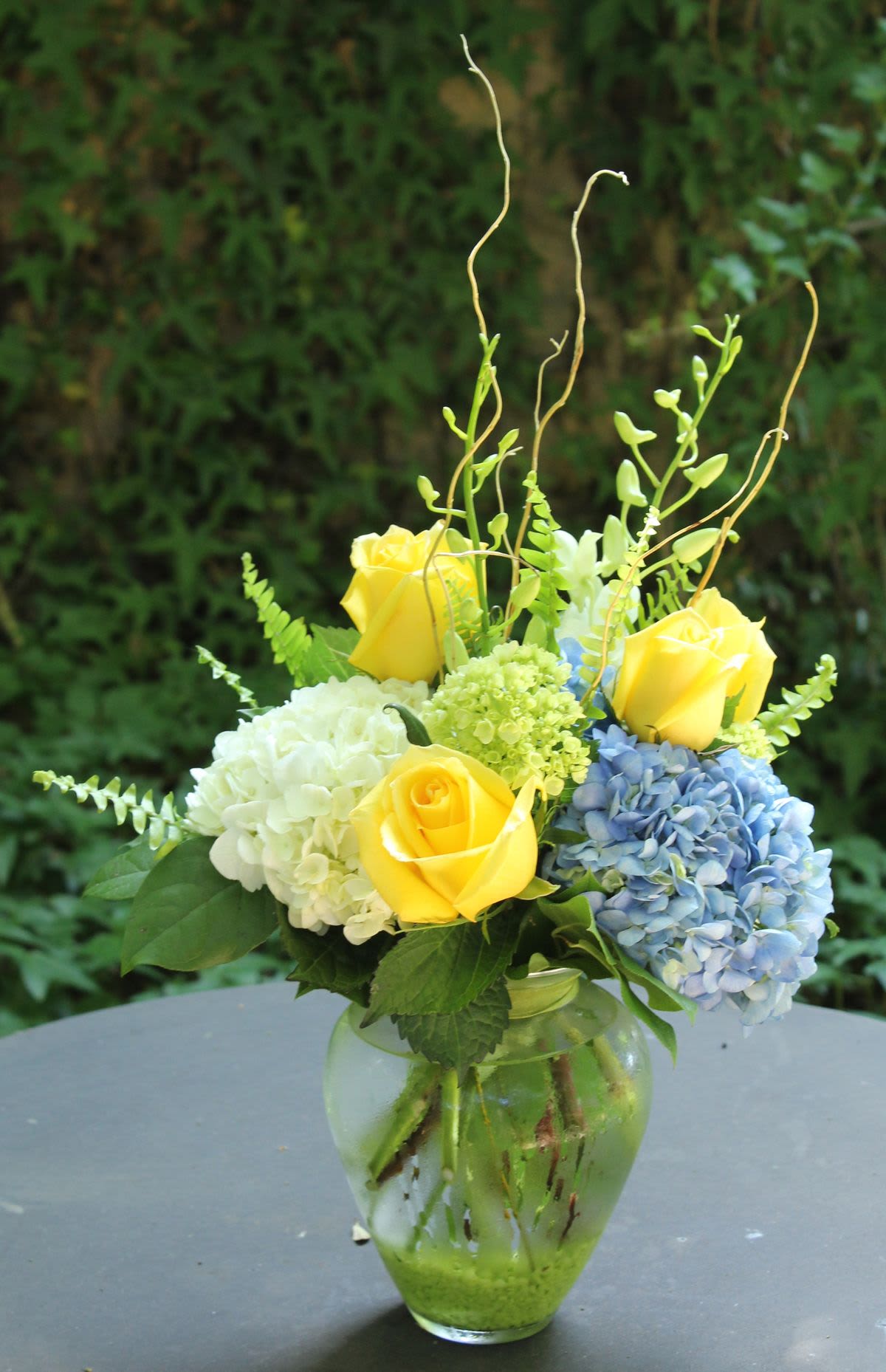 Lemon Berry Arrangement - With a high-energy mix of lemon yellow, cornflower blue, and vivid spring green, this lively arrangement captures the essence of a sunny afternoon.