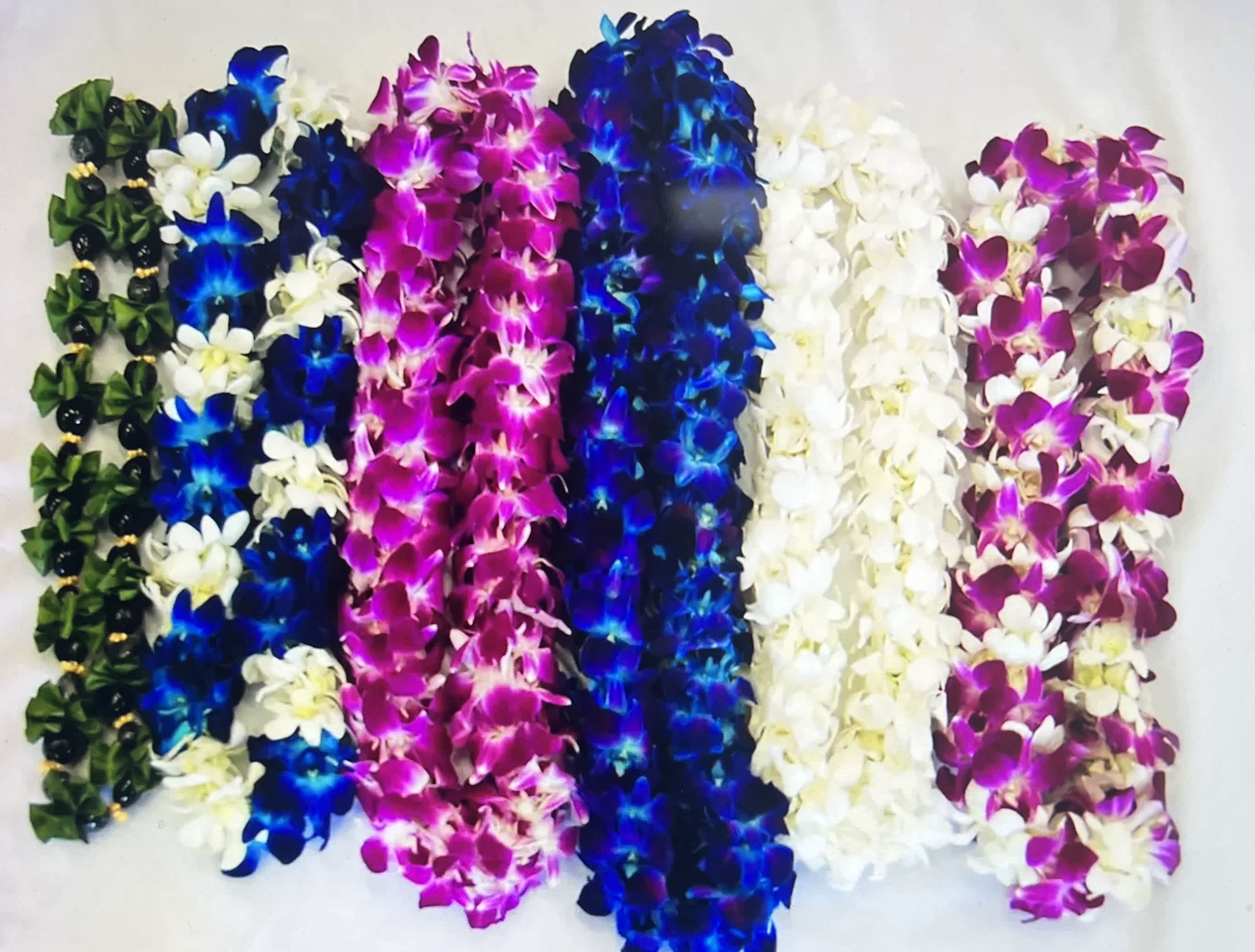 Colorful orchid leis arranged in rows on a white background