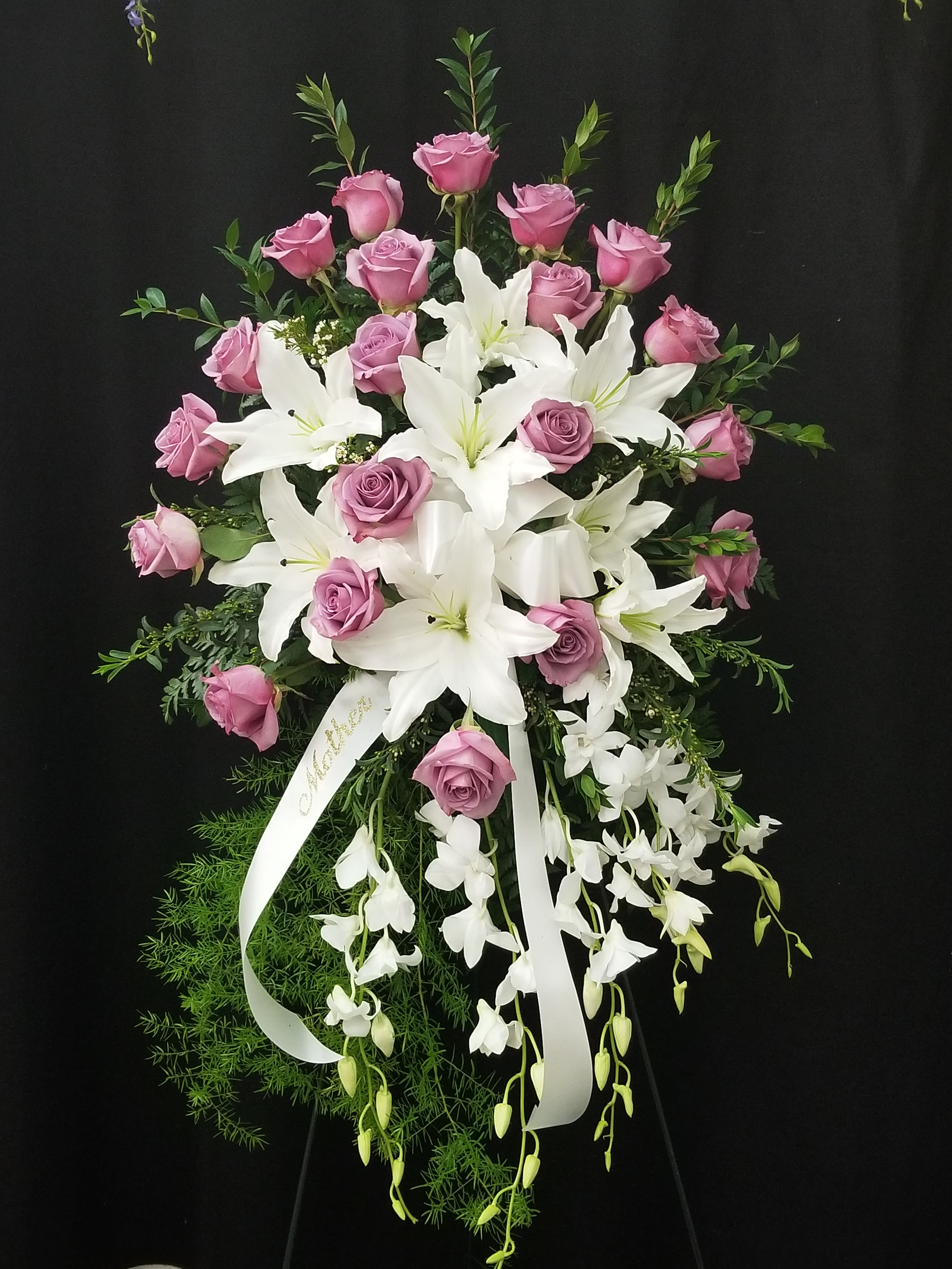 Pink roses and white lilies in a cascading floral spray with ribbon
