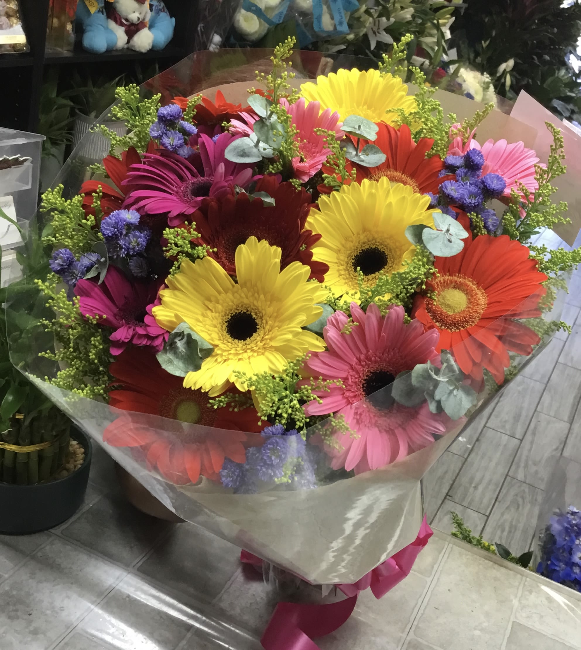 Bright mixed gerbera daisy bouquet wrapped in clear paper