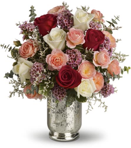 Bouquet of red, white, and peach roses in a silver vase