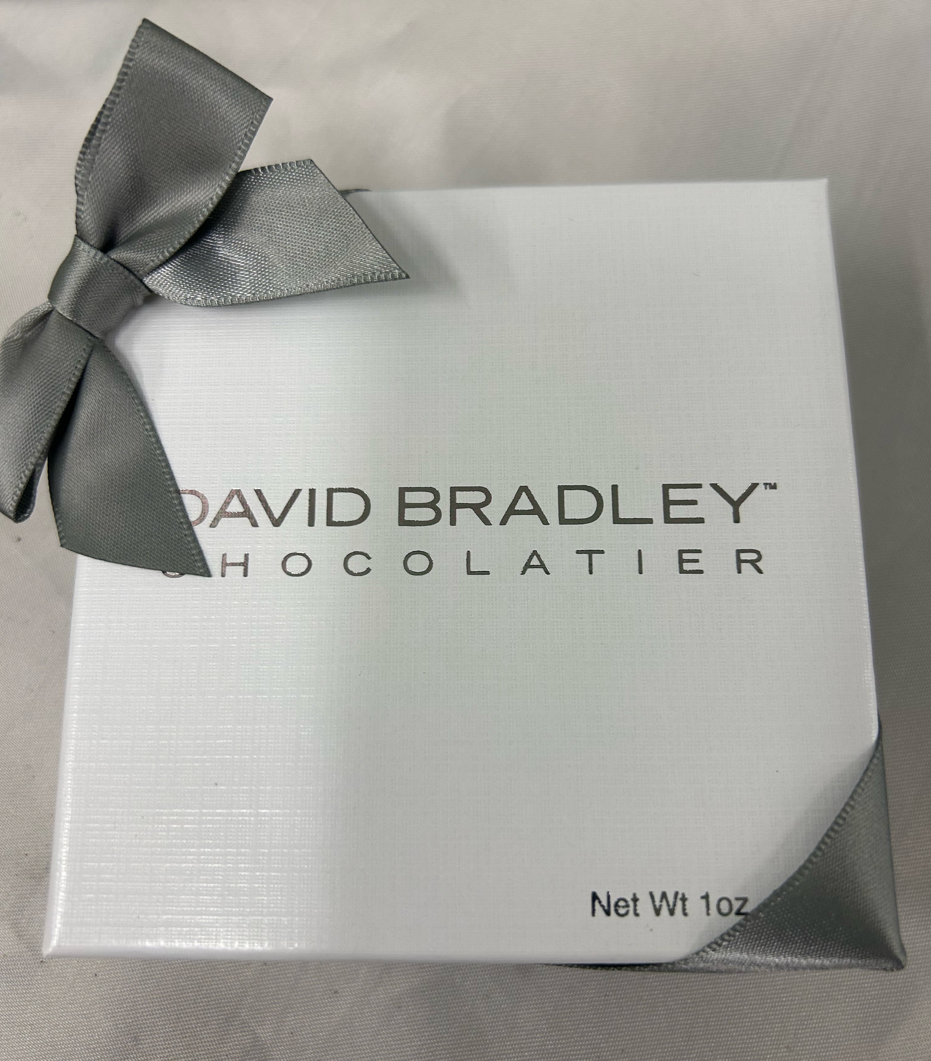 White chocolate gift box with a gray ribbon bow