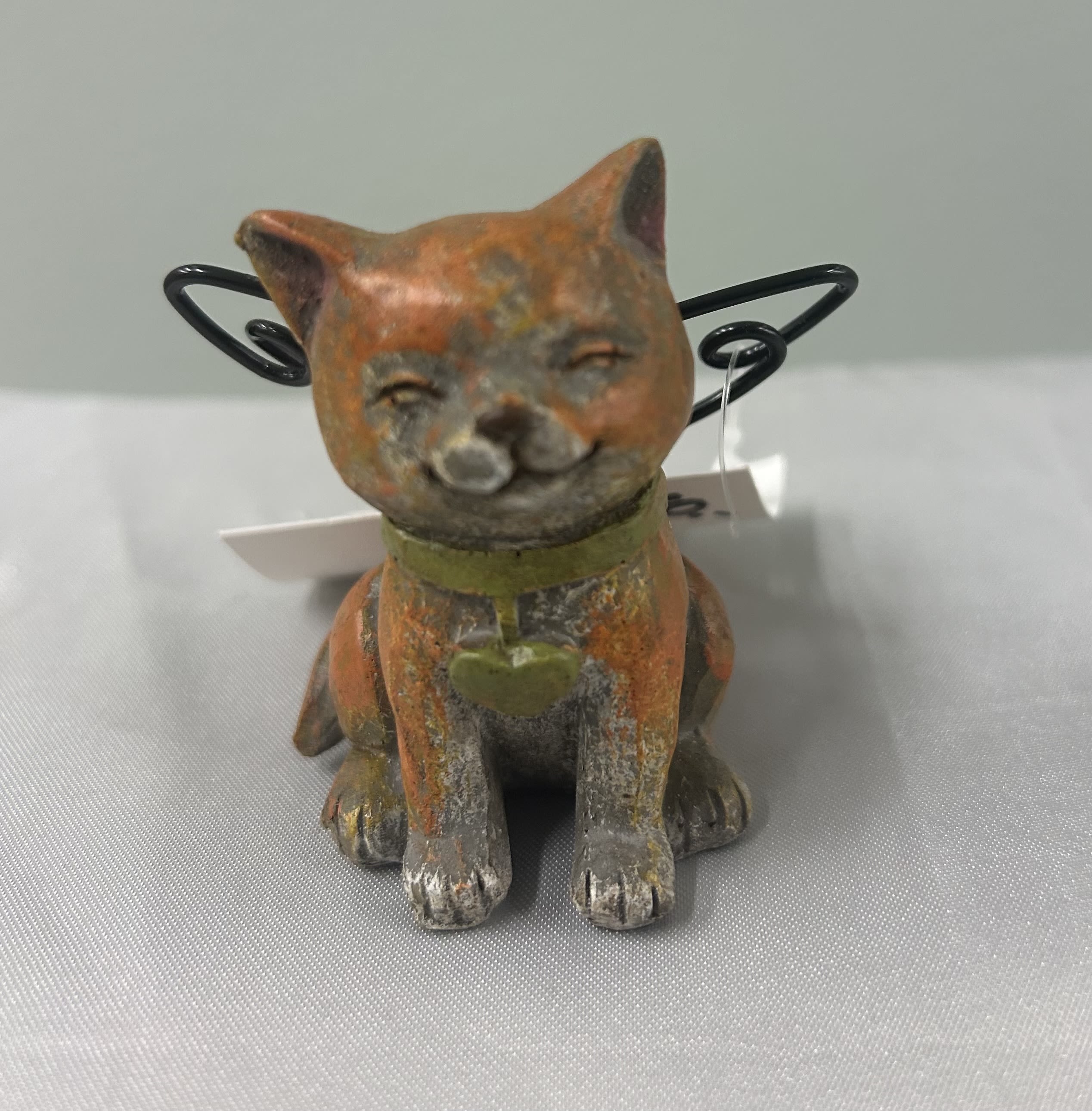 Small cat figurine with wire wings and a collar