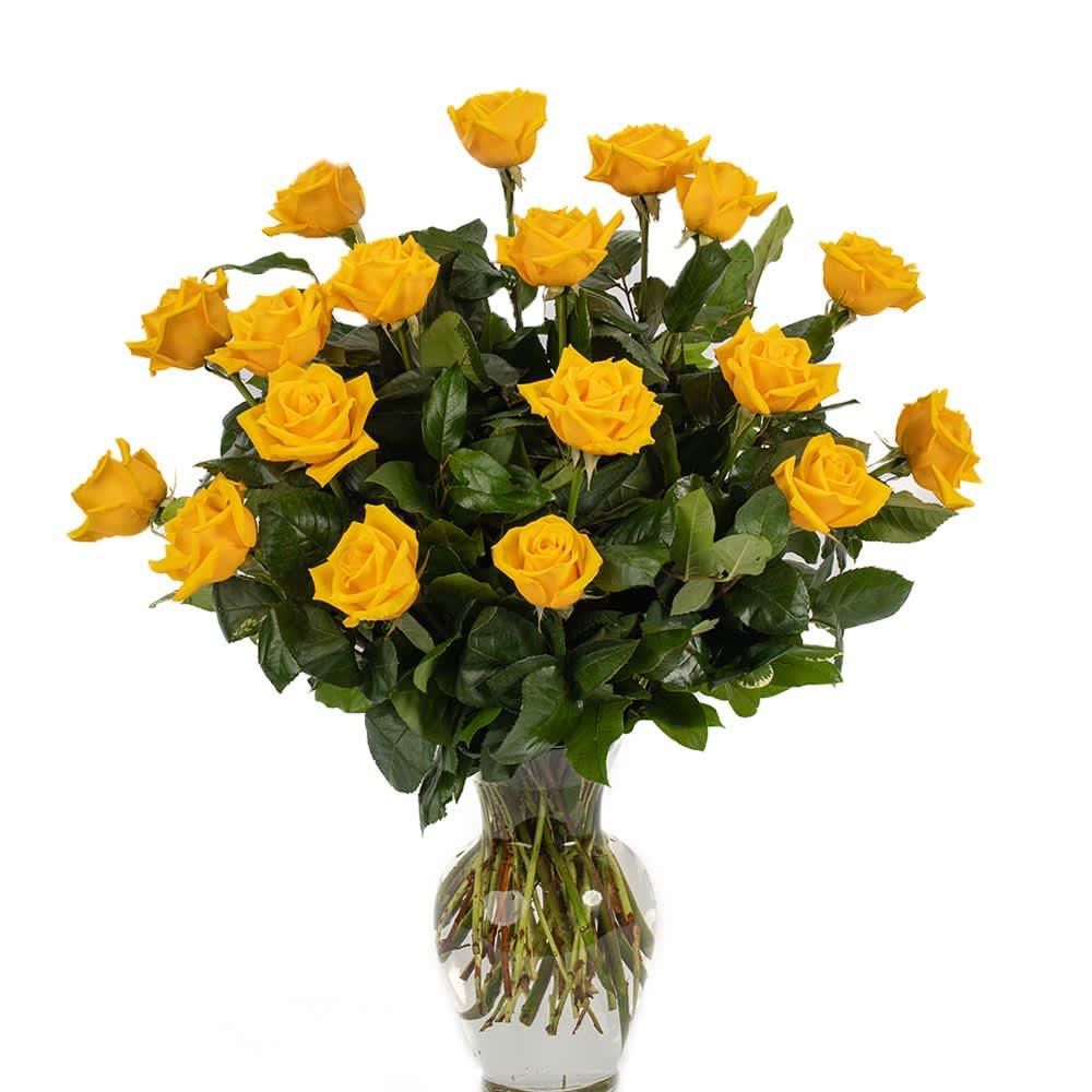 Tall arrangement of yellow roses in a clear glass vase