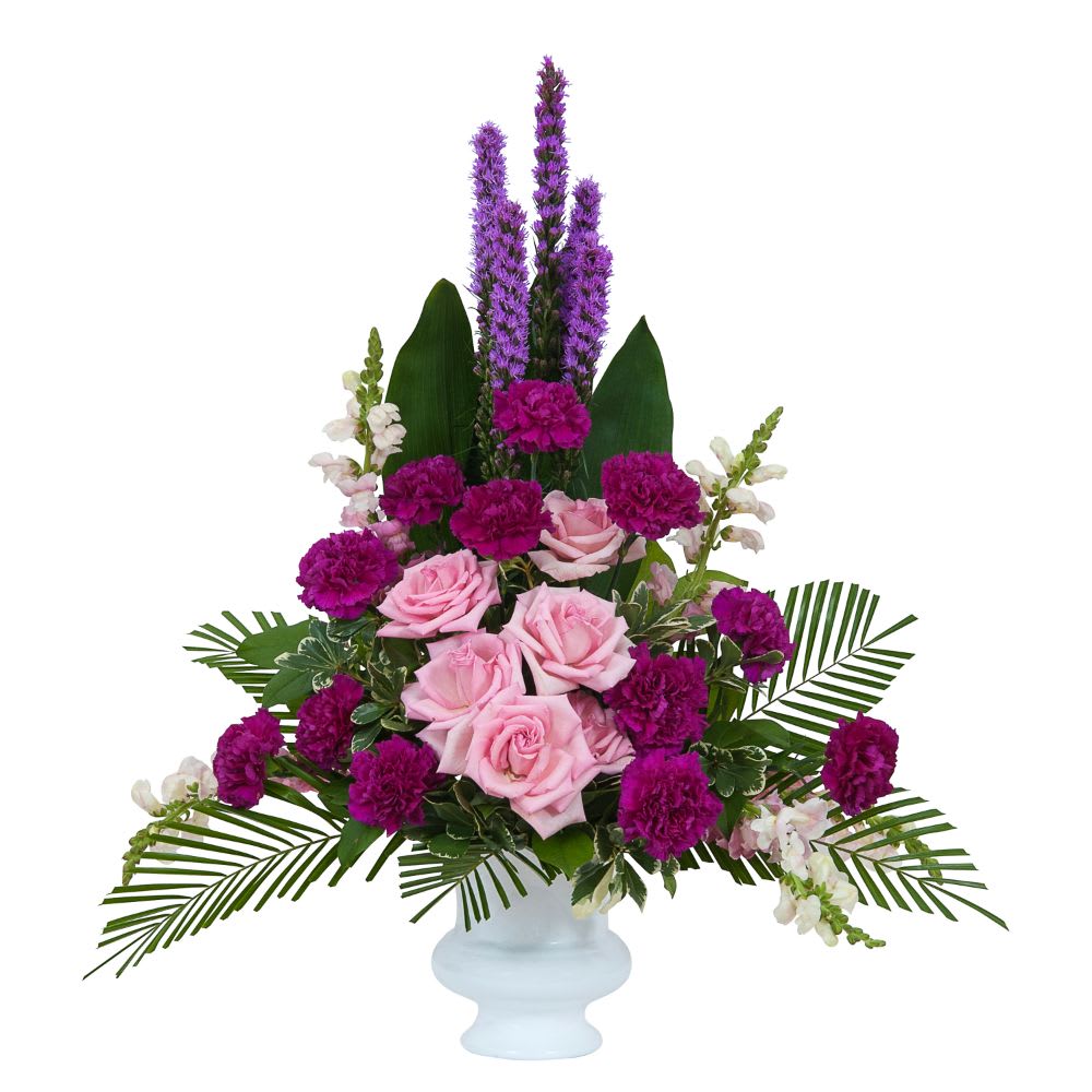 Pink roses and purple flowers arranged in a white vase