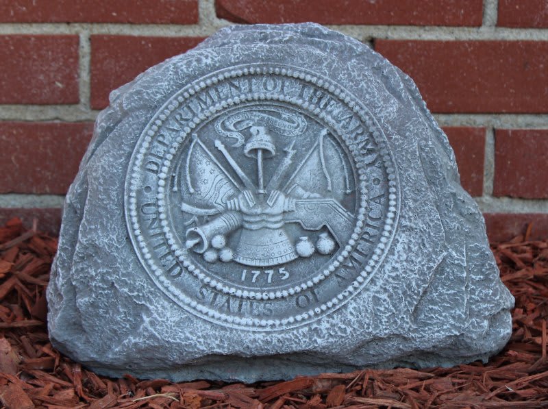 Engraved stone marker with a circular seal against a brick wall