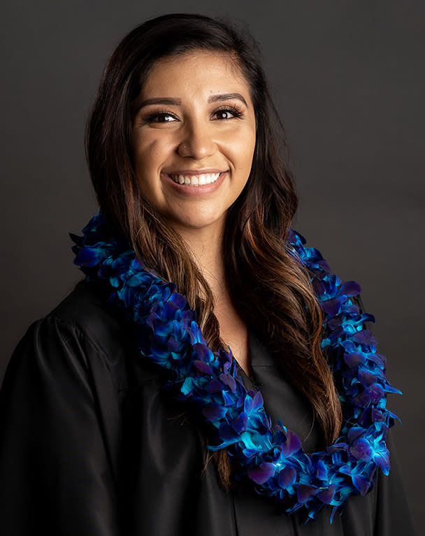 Woman wearing a blue and purple flower lei over a black top