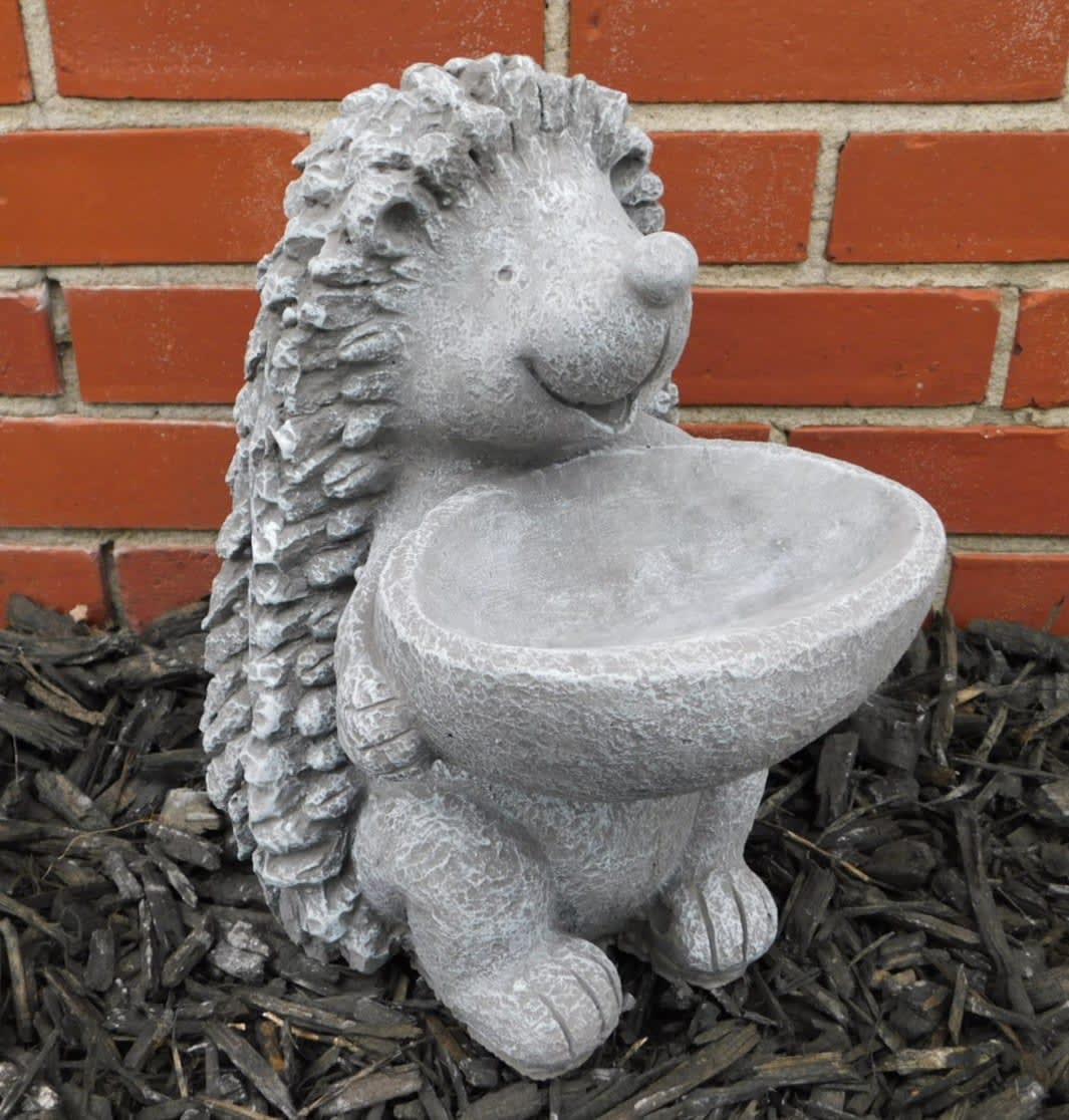 Stone hedgehog garden statue holding a shallow bowl