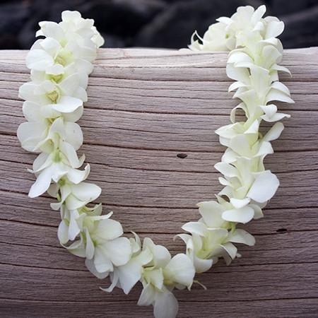 White orchid lei on a wooden surface