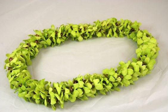 Lime-green floral lei made of clustered blossoms on a light background
