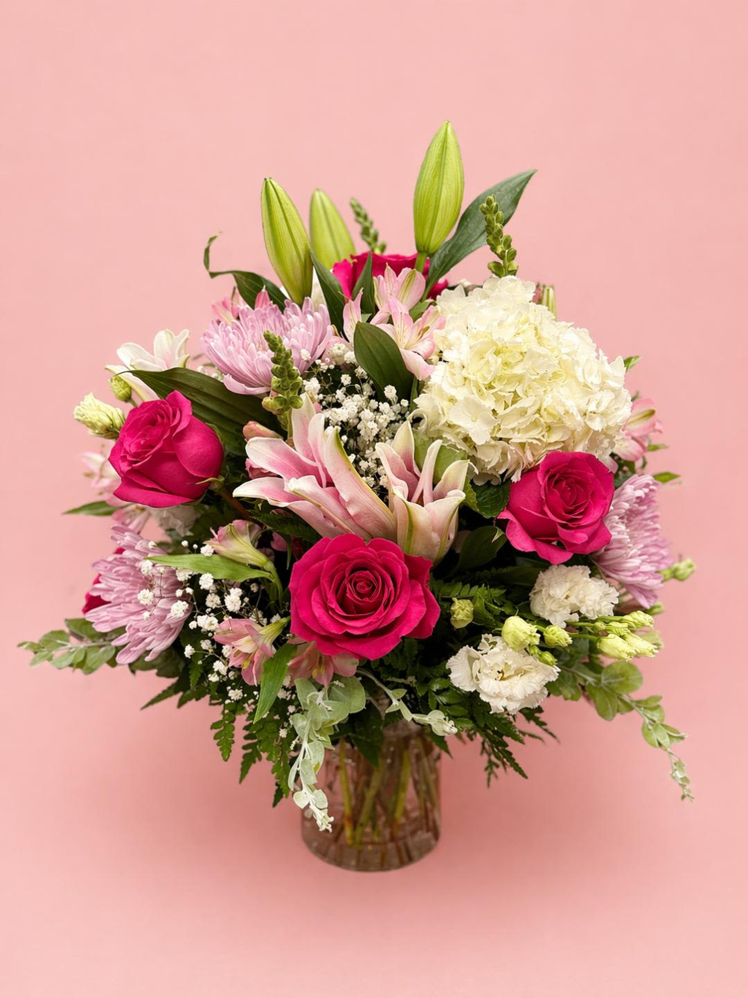 BLUSH GARDEN - “A stunning glass vase filled with a vibrant mix of fresh flowers, including elegant roses, graceful lilies, lush hydrangeas, and a delightful assortment of seasonal blooms. This beautifully arranged bouquet radiates color and charm—making it the perfect gift!"  *Med Size Vase Arrangement. 
