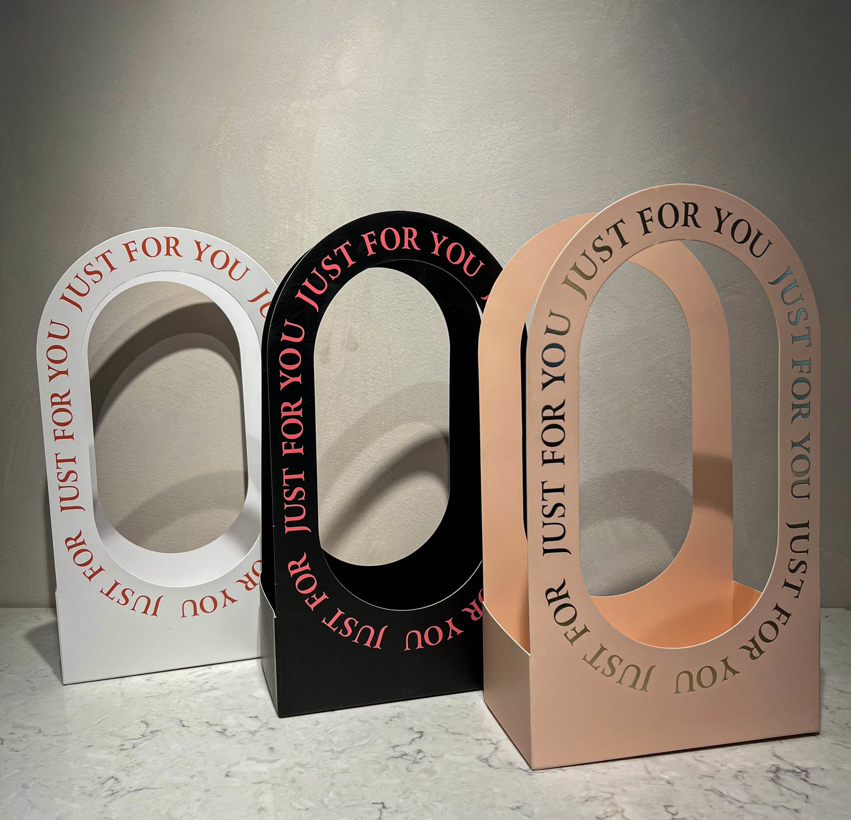 Three arched gift boxes with "Just For You" text in white, black, and blush.