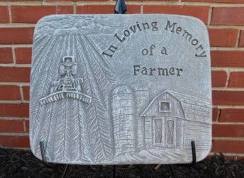 Memorial plaque with a farm scene and the words 'In Loving Memory of a Farmer'