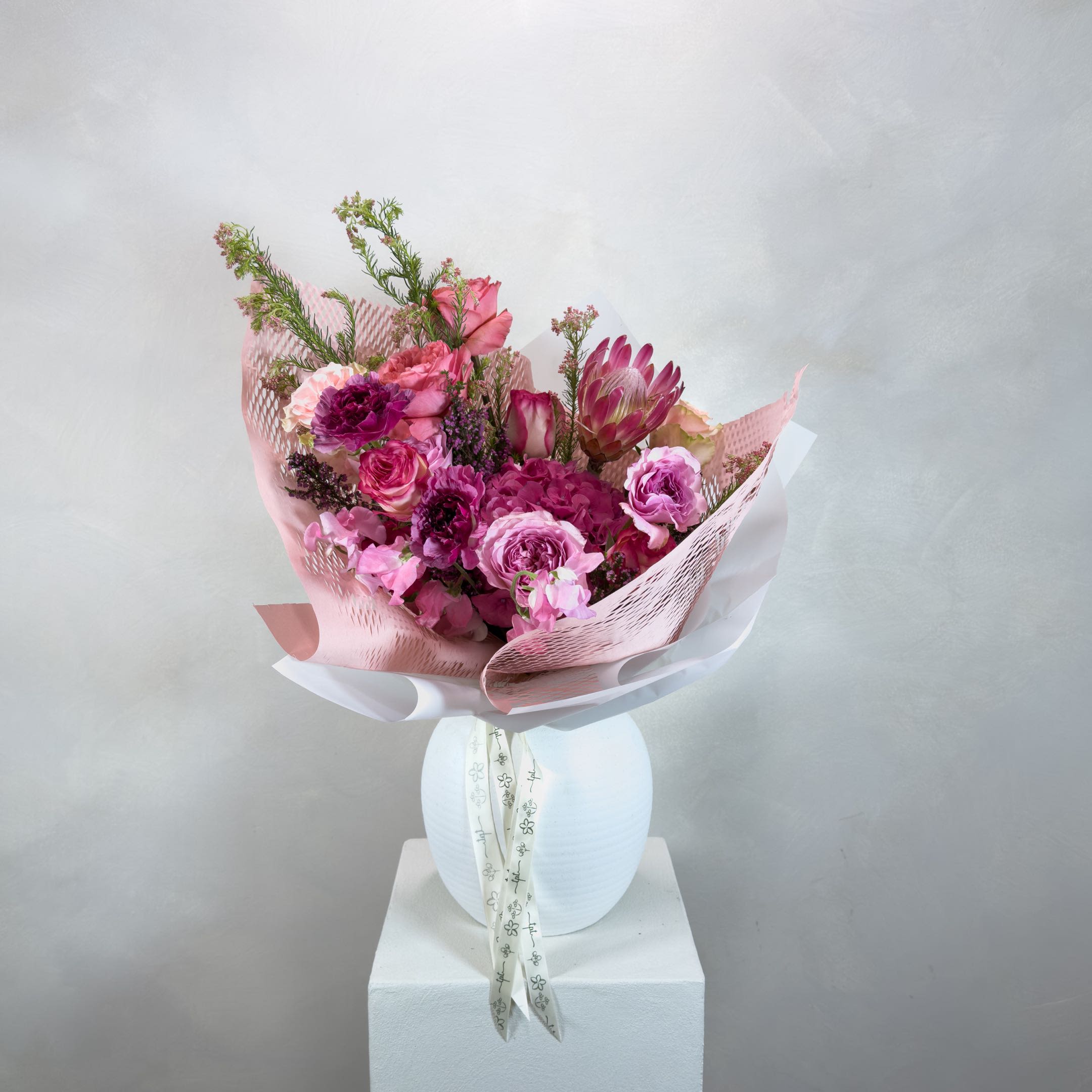 For Eomeoni in Pink - A soft, all-pink bouquet composed in layered tones - bringing together seasonal and classic flowers in a warm, gentle palette. Designed intuitively, each arrangement is one of a kind, allowing texture, movement, and color to shape the final form.  What’s Included:  – Seasonal flowers in pink tones – Handwritten note + care instructions – Carry-out bag – Water source to keep stems fresh – Bouquets with 18+ stems include a water pouch for transport  Please Note:  Images are for inspiration only. We do not replicate past designs or recreate another florist’s work. Each bouquet is uniquely handcrafted with care and intention.