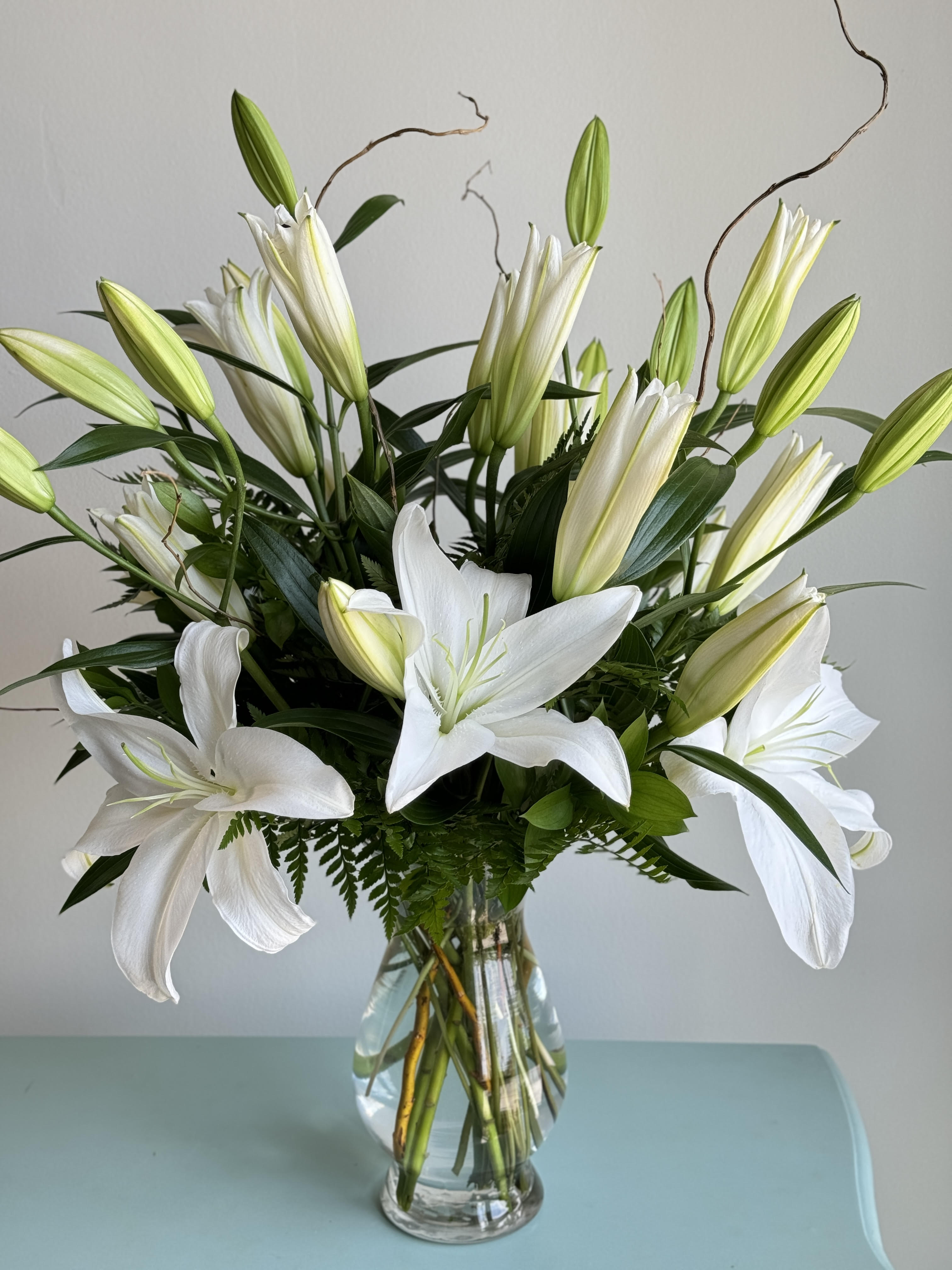 White lilies arranged in a clear glass vase