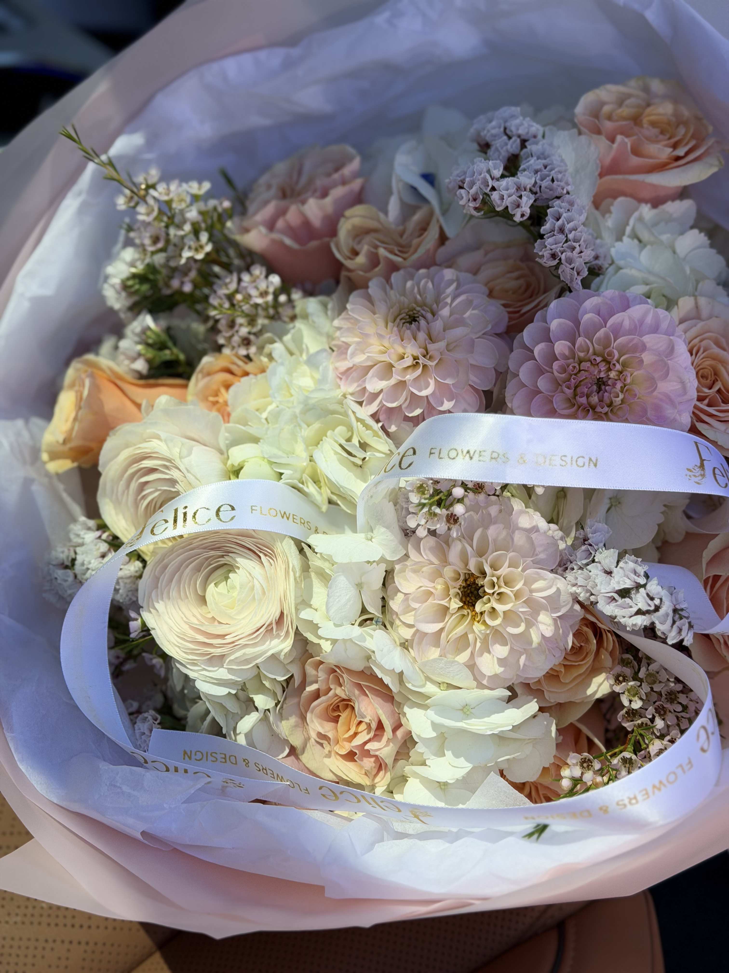 Champagne Blush Luxury Bouquet - A refined and luxurious bouquet designed in soft champagne, blush pink, and creamy white tones, featuring premium ranunculus, garden roses, hydrangeas, and delicate seasonal blooms. This arrangement offers a sophisticated and airy garden-style look with soft textures and elegant layering. The neutral pastel palette creates a timeless and graceful aesthetic, perfect for high-end gifting. Wrapped in elegant soft paper and finished with signature ribbon detailing, this bouquet embodies understated luxury and modern floral design. Perfect for Birthday, Anniversary, Bridal Gift, Baby Shower, Thank You, Get Well, and Just Because. Please note: due to seasonal availability, some flowers may be substituted. However, the overall color palette, bouquet size, and elegant garden style will remain consistent with the photo. Handcrafted by Felice Flowers &amp; Design.