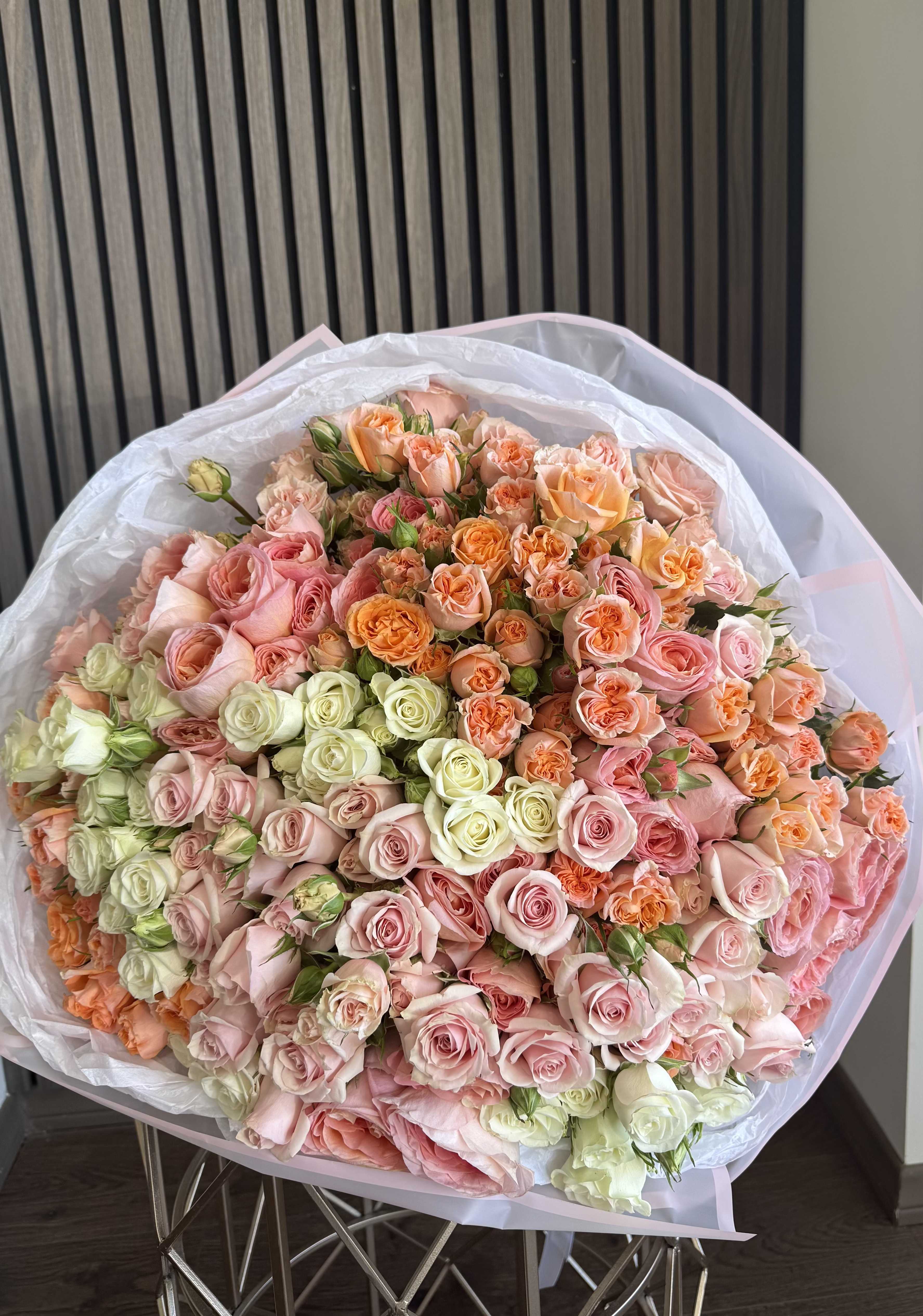 Peach Blush Grand Luxury Bouquet - A breathtaking grand luxury bouquet composed of premium roses and spray roses in soft blush pink, peach, and creamy ivory tones. Designed in a full, round, and dense garden style, this bouquet creates an elegant ombré effect with delicate transitions between soft pastel shades. The rich layering and abundance of blooms make it a true statement piece. This arrangement is carefully wrapped in premium white paper to highlight its volume and luxury aesthetic, representing the signature style of Felice Flowers &amp; Design. Perfect for Anniversary, Romantic Gift, Luxury Surprise, Birthday, and Special Occasions. Please note: due to seasonal availability, some flowers may be substituted. However, the overall color palette, fullness, and luxurious appearance will remain consistent with the photo.