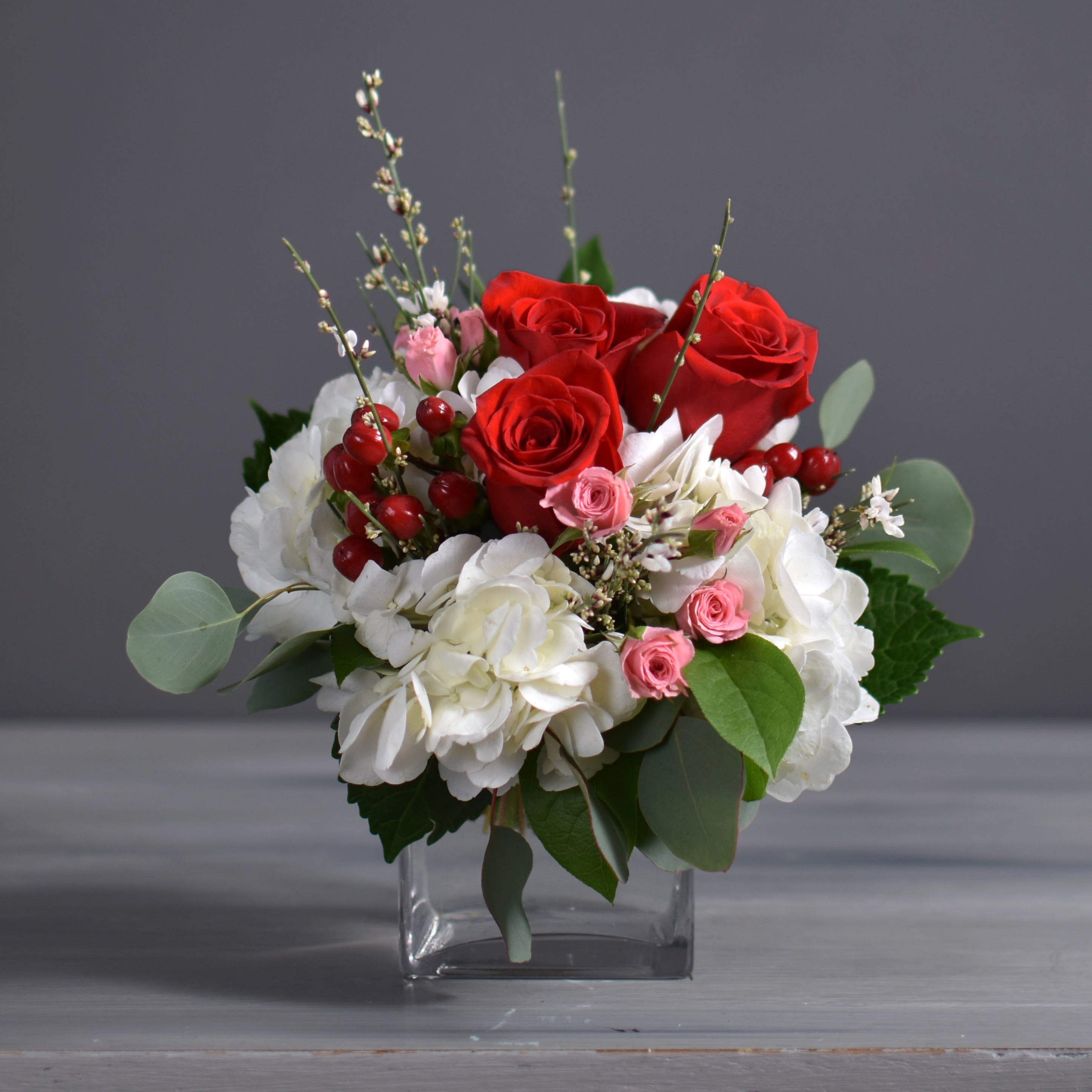 Bailey - Red Roses, Pink Sprays, White hydrangea and red hypericum with mixed Filler.