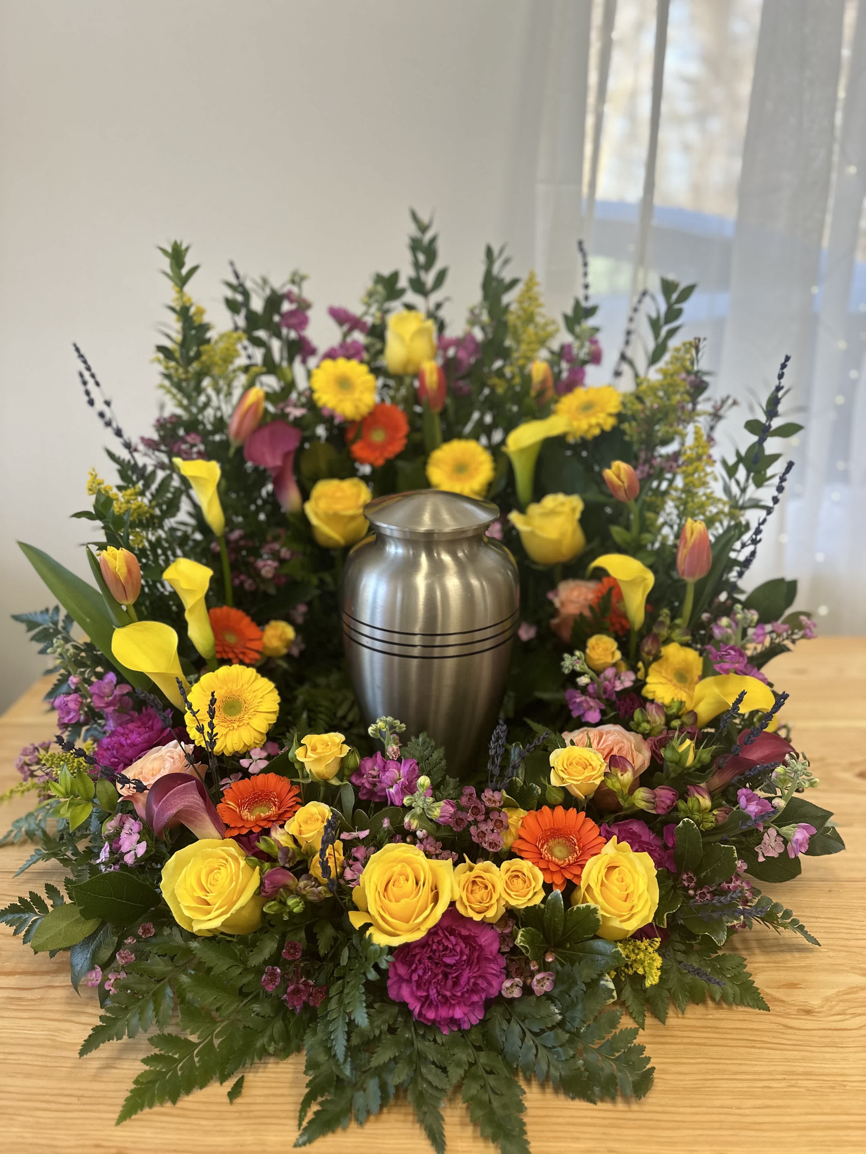 Colorful floral wreath around a silver urn centerpiece