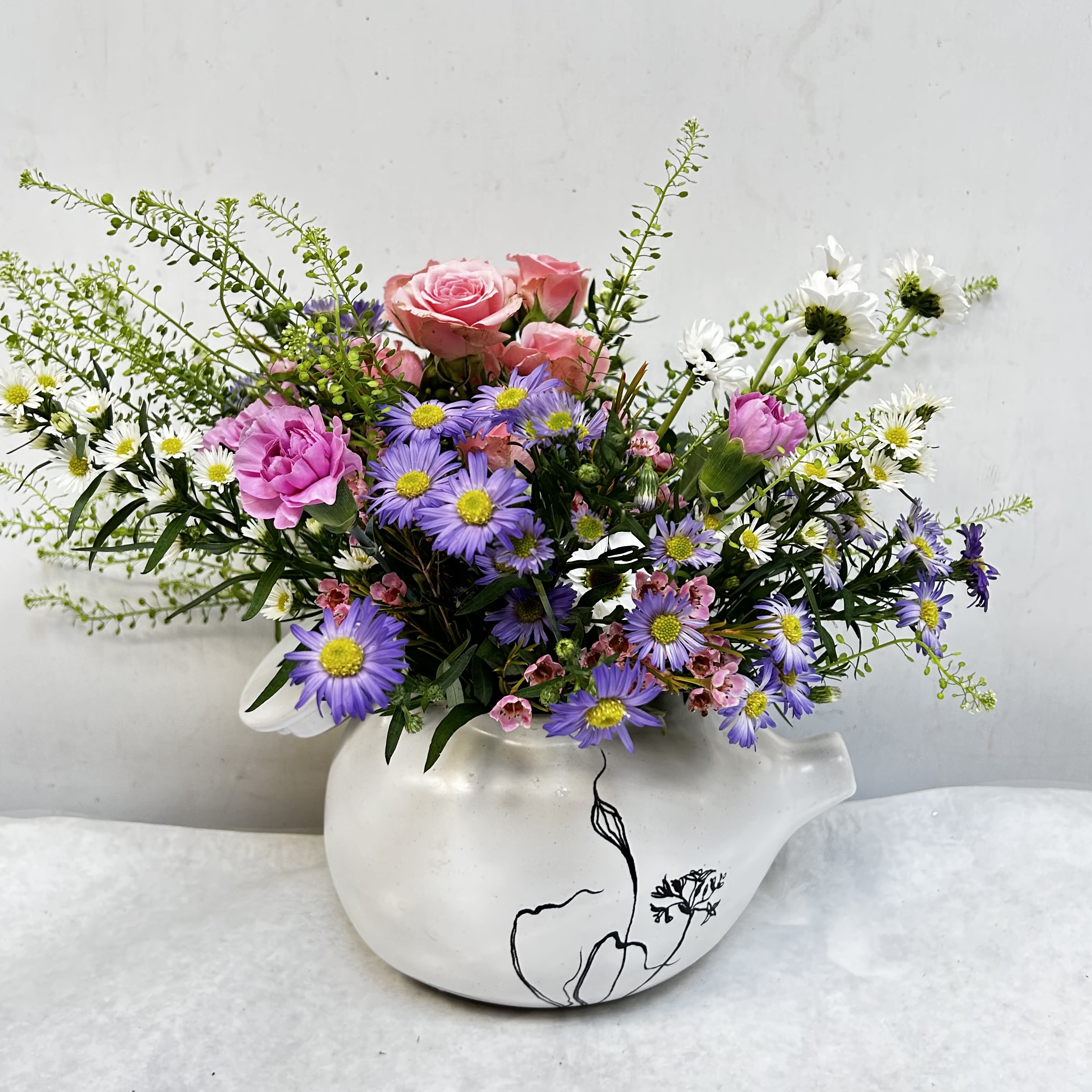 Mom's Cup of Tea - Soft pink roses lead this airy Mother's Day or everyday bouquet, a "Mom's Cup of Tea" arrangement that feels like a gentle garden visit. The mixed-color palette of pink, purple and white reads fresh and cheerful-perfect as a birthday bouquet, a thank-you gift, or a just-because surprise that will make the person you're thinking of feel seen and cherished. 