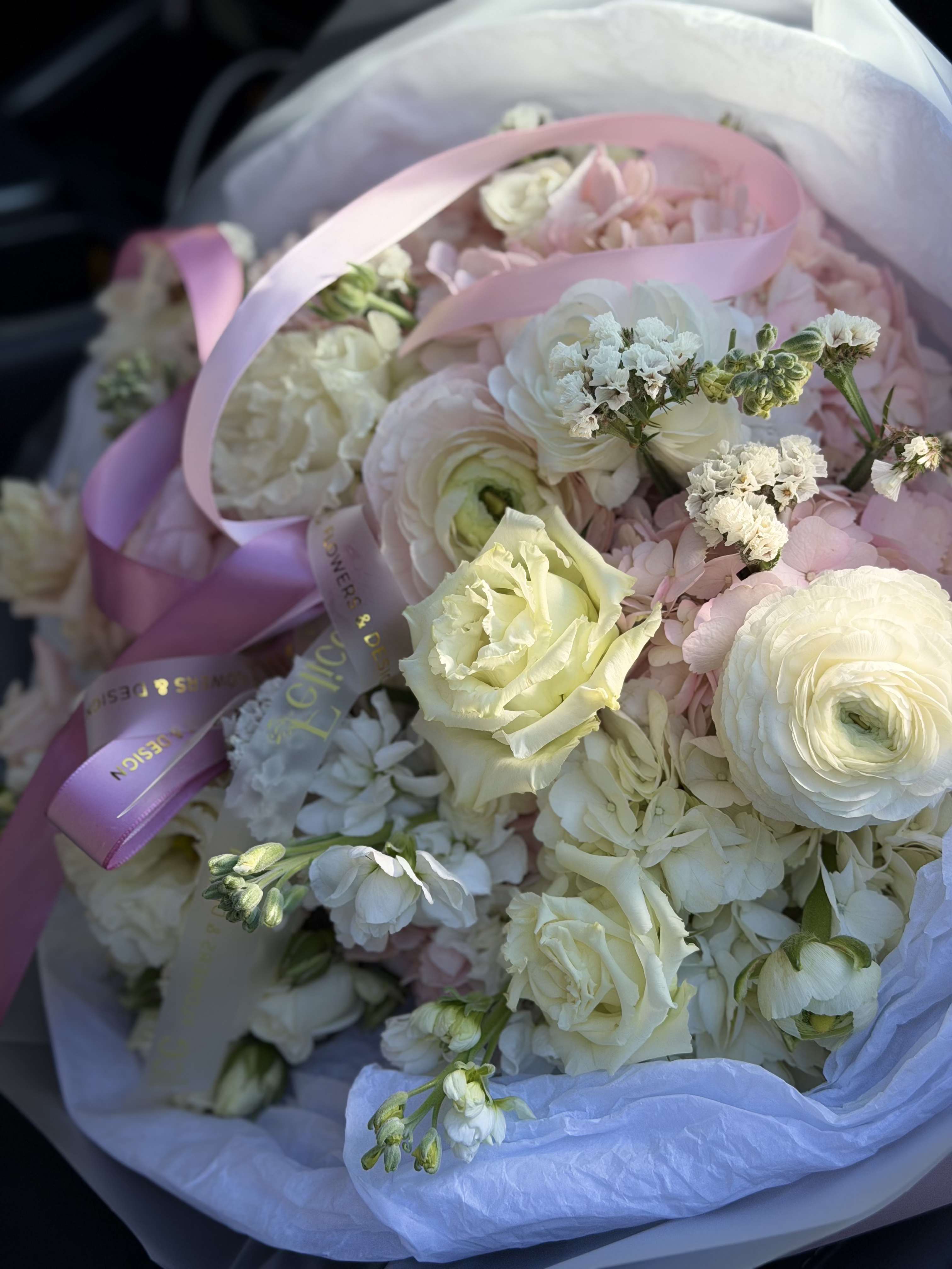 Soft Ivory Garden Bouquet - A refined and elegant bouquet featuring soft ivory and blush blooms arranged in a delicate garden style. This arrangement combines creamy white roses, ranunculus, and seasonal flowers with gentle blush accents, creating a timeless and sophisticated look. Designed with a light, airy feel and wrapped in premium paper with signature Felice Flowers &amp; Design ribbon. Perfect for Weddings, Anniversaries, Sympathy, Get Well, or elegant everyday gifting. Please note: flower varieties may vary due to seasonality while maintaining the same color palette and overall aesthetic.