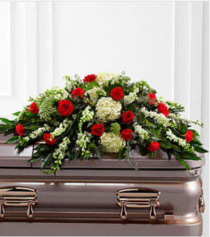 Red roses and white flowers arranged on a casket