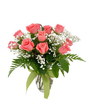 Pink roses arranged in a clear glass vase with baby's breath