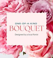 Mothers Day Florist Choice -  Soft blush to deeper pink roses are densely packed to form a layered, textured bouquet that feels both classic and abundant. A white scalloped square sign centers the design, giving a clean, gift-ready presentation that highlights the florist's message. The palette of pinks and whites keeps the look elegant and timeless; stems are arranged tightly for a full silhouette that photographs beautifully and commands attention.  This bouquet is the kind of gift that makes her feel seen and adored-ideal for breakfast surprises, brunch deliveries, or a bedside reveal. Standard care: keep in fresh water, trim stems if needed, and display away from direct heat to extend bloom life. Ordering is simple for same-week delivery from our Fort Myers shop to ensure she gets these roses at peak beauty.