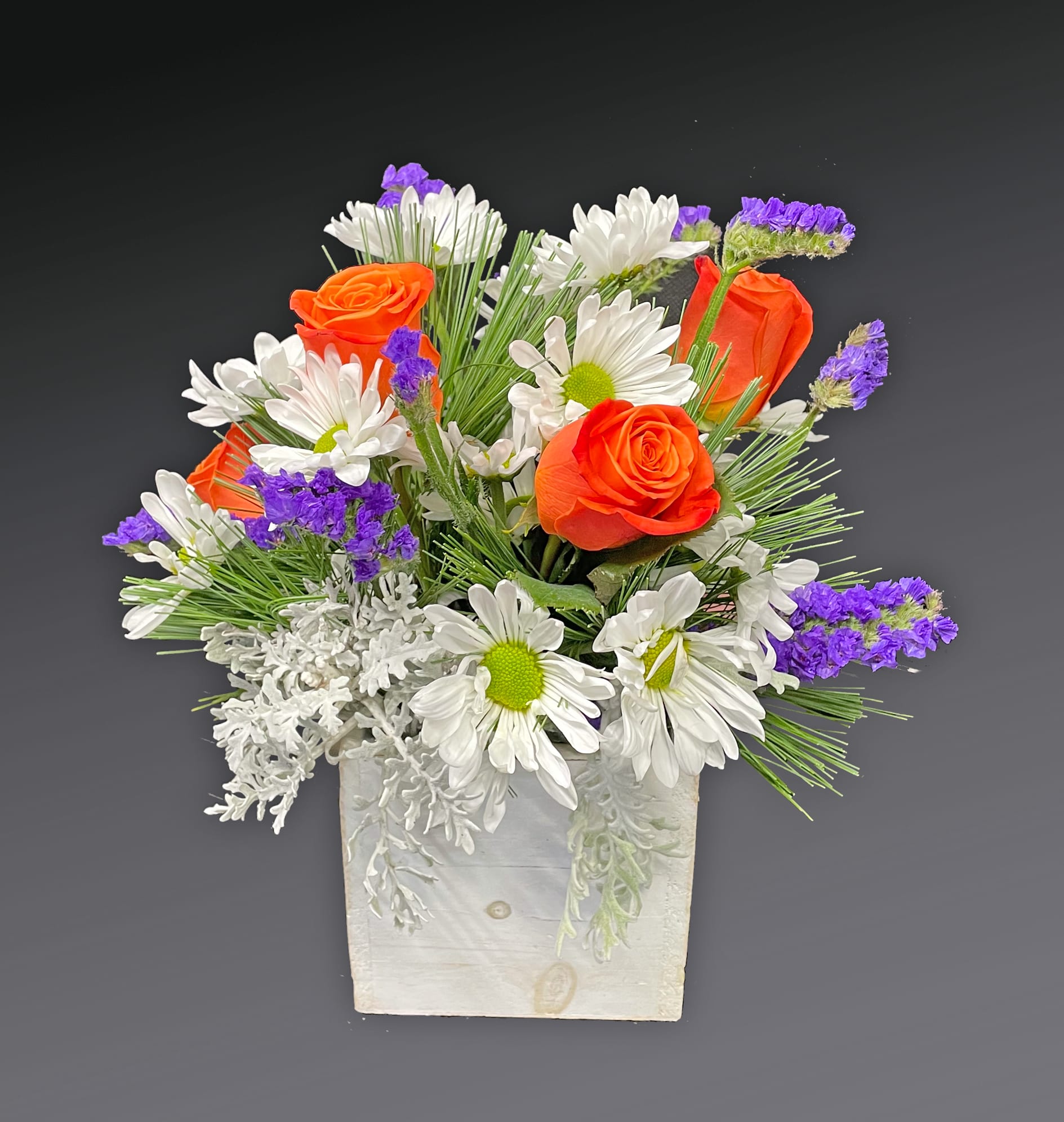 Orange roses and white daisies in a white wooden box