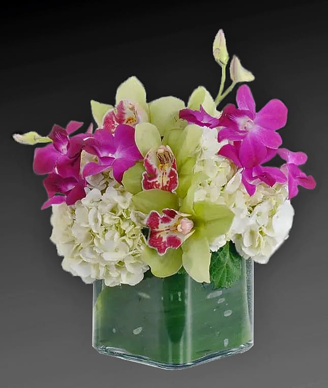 Bouquet of white hydrangeas and pink orchids in a glass vase