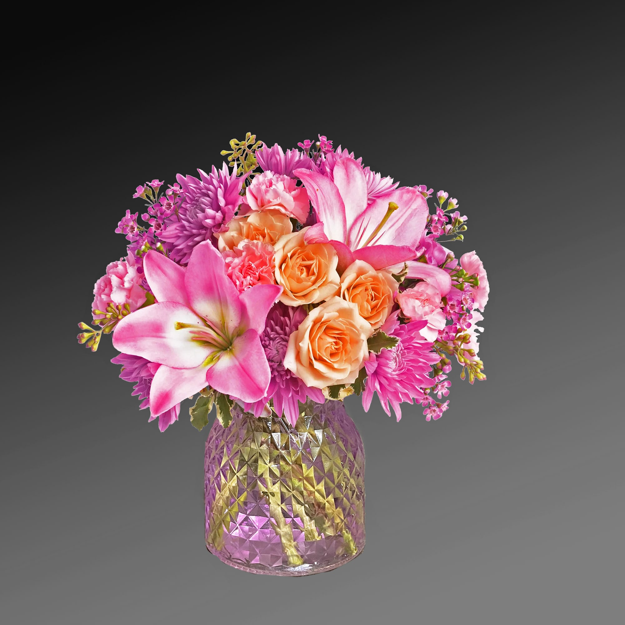 Pink and peach mixed bouquet in a faceted glass vase