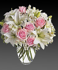 Arrive In Style - Express your love with the eloquence of Shakespeare - without saying a word. She'll adore this exquisite bouquet of roses and lilies and other pastel favorites in a classic ginger vase. And she'll know just the words to let you know. Light pink roses, white asiatic lilies, white alstroemeria and white cushion spray chrysanthemums are mixed with white statice and variegated pittosporum in a clear, rounded vase.