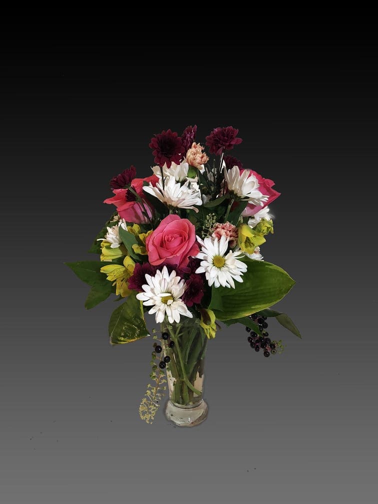 Mixed bouquet of pink roses and white daisies in a clear glass vase