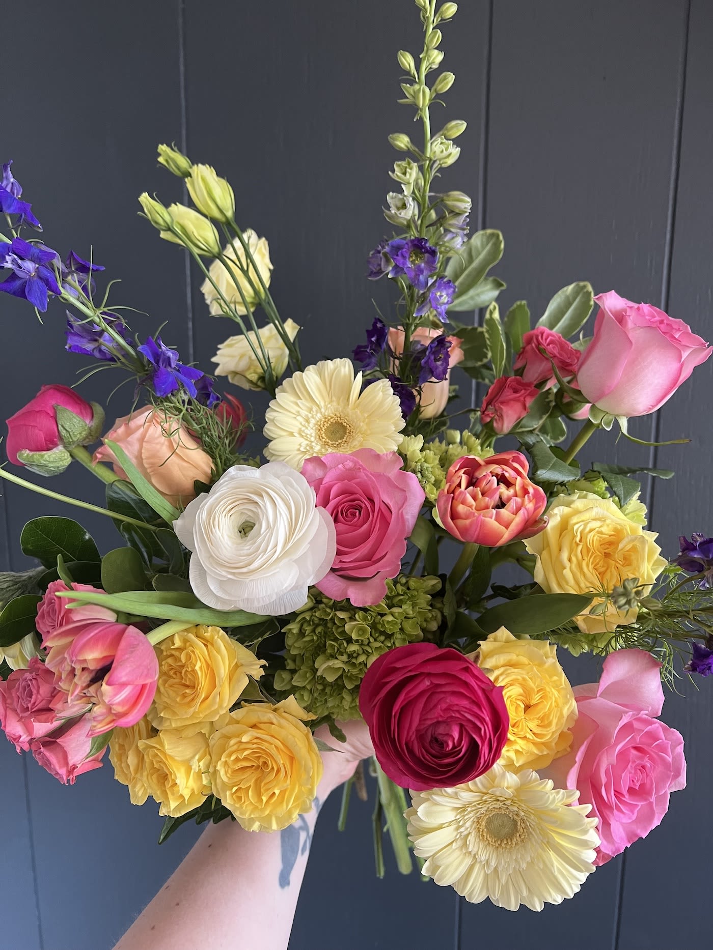 ARTFUL SEASONAL HAND-TIED BOUQUET - Seasonal, colorful flowers and foliage artfully arranged, wrapped in tissue and ready to drop in a vase at home.  Year round flowers that we typically stock: specialty rose, spray rose and garden rose, ranunculus, anemone, mini hydrangea, gerbera daisy, protea, lisianthus, chrysanthemum, larkspur, snapdragon, delphinium, stock, aster, dianthus, hypericum, feverfew, astrantia, leucodendron.