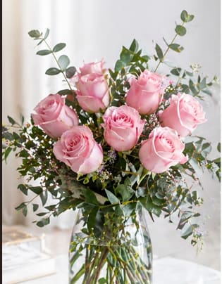 Delicate Pink Rose Bouquet - Picture-perfect soft pink roses make a beautiful gift for the lovely lady in your life. Wife mother daughter or sweetheart she's sure to cherish this bouquet of pastel pink roses accented with delicate greens and arranged in a clear glass vase.