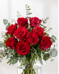 Red Rose Bouquet - Nothing speaks of love so much as a bouquet of beautiful red roses. Arranged with seeded eucalyptus in a classic glass vase this bouquet is a gift to her heart from yours.