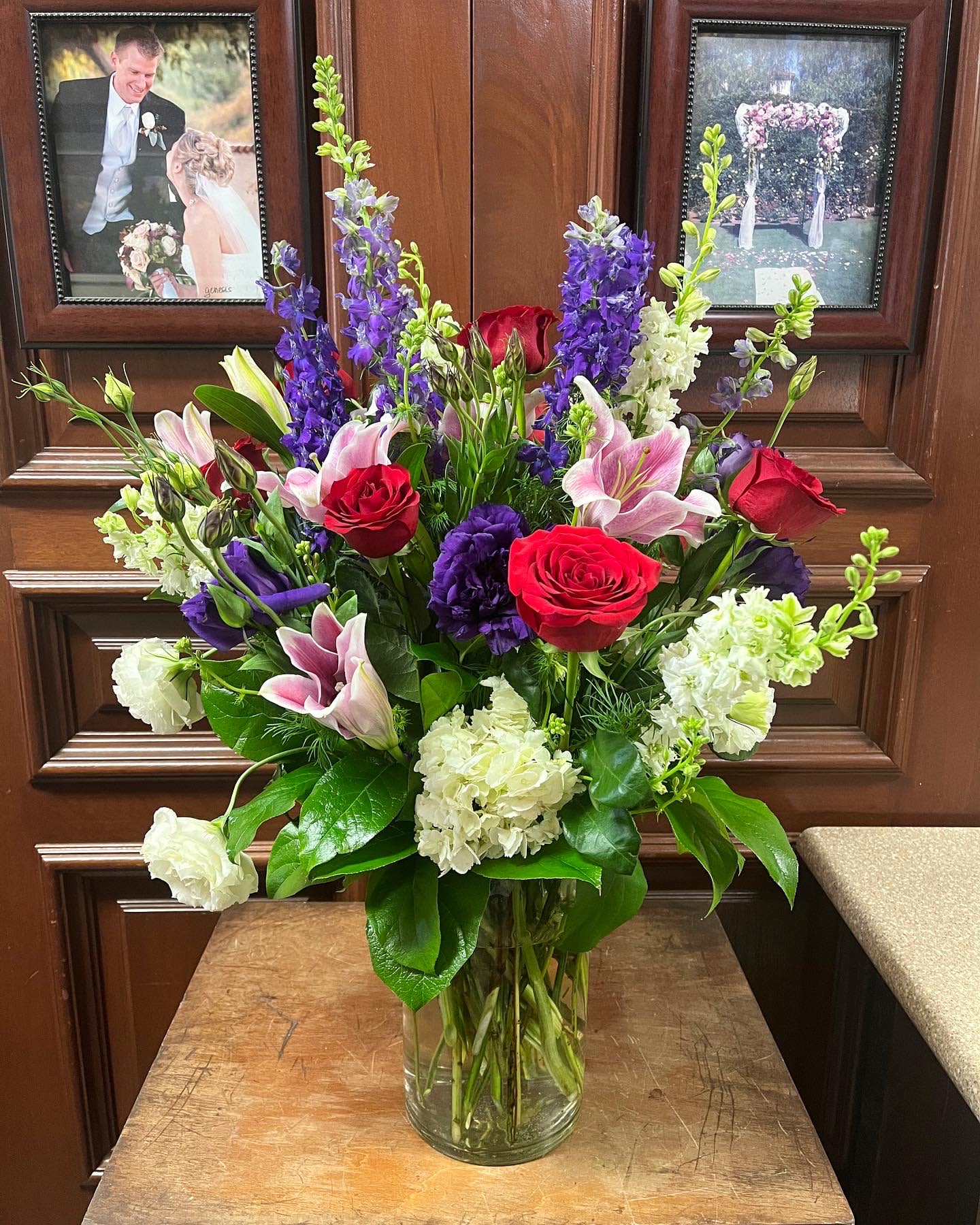 Stargazer Meadow - Recipe: Purple and White Larkspur, Red Roses, Pink Stargazer, Purple Lisianthus, White Hydrangaes and green succulent in a short vase. Availability: All year round Design View: All Facing View Photo shown: Standard 