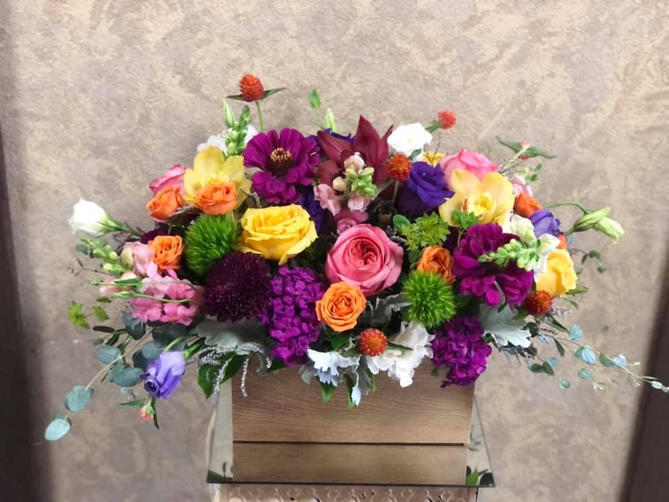 Colorful mixed flower arrangement in a wooden box
