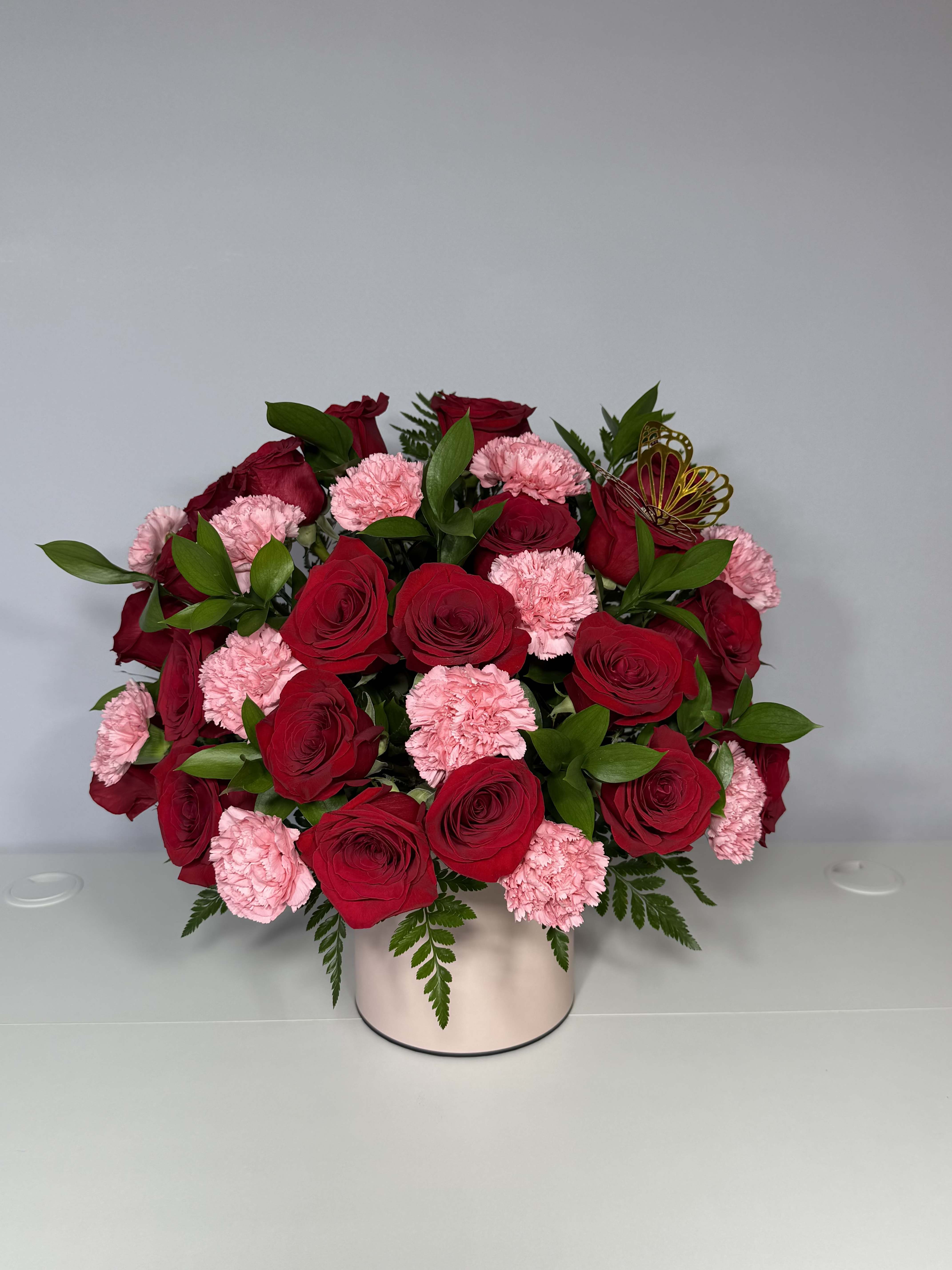 Rosa  - A beautiful and elegant arrangement of red roses and carnations, beautifully presented in a soft pink box. Impressive, timeless, and  designed to stand out from the moment it’s seen. 