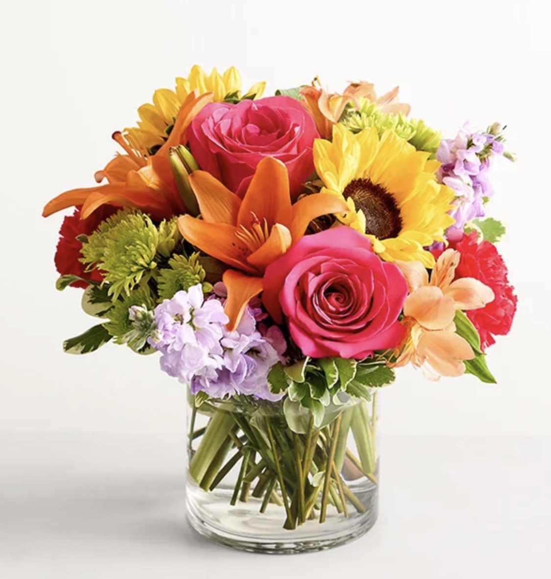 Floral Embrace - Like a warm embrace, this vibrant flower bouquet delivers your sentiments to someone special. A rich gathering of yellow and orange blooms, with pops of bright pink and purple, it's more than a gift… it's a way to express how you feel. 