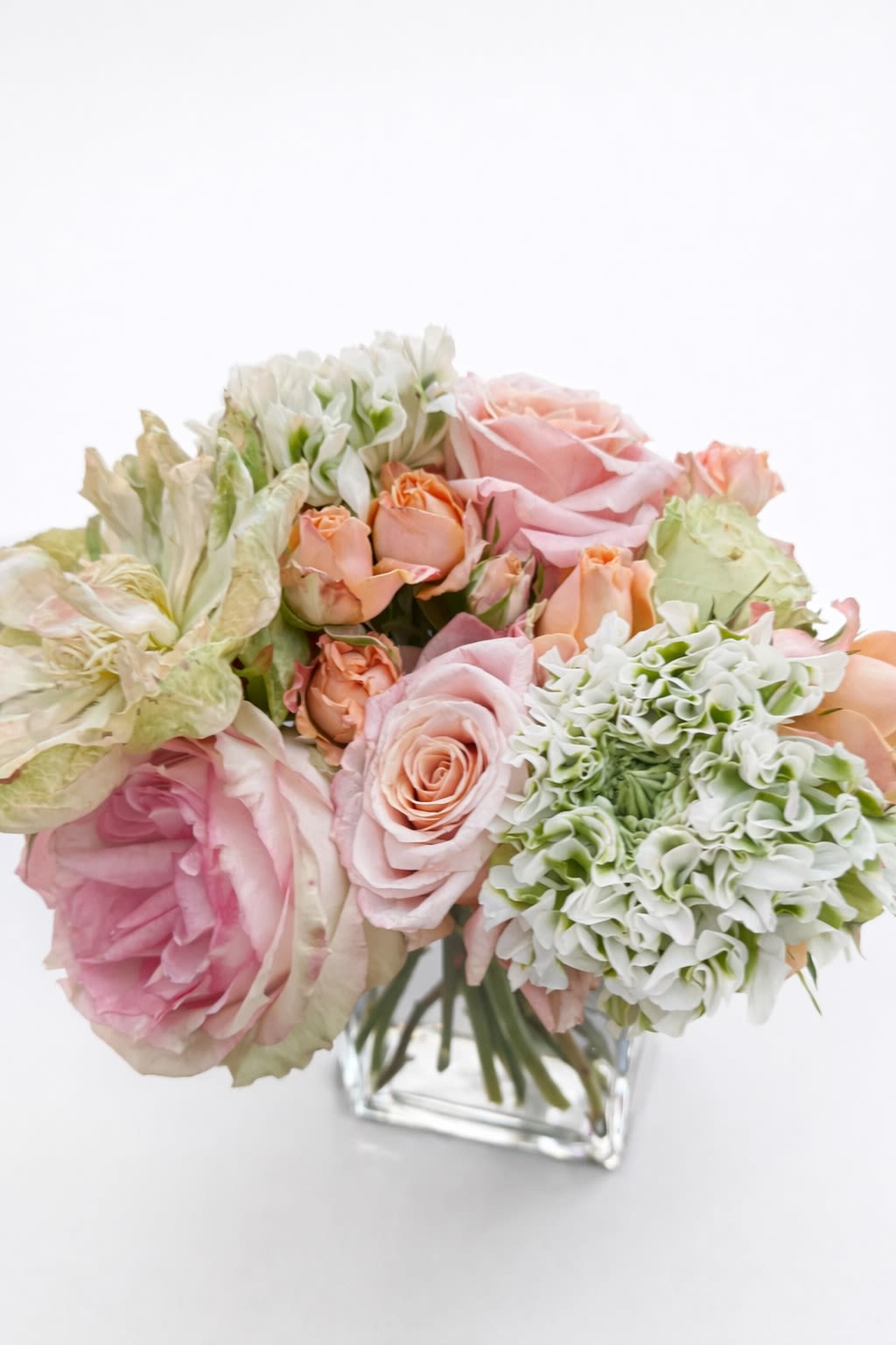 Soft Devotion - A gentle layering of blush, peach, and soft green, Soft Devotion carries a quiet, intimate beauty—one that feels both delicate and deeply rooted in care.  Designed for the mom whose love is expressed in the smallest, most meaningful ways—the quiet gestures, the steady presence, the unwavering heart—this arrangement reflects a devotion that is constant, tender, and profoundly felt.  With its softened palette and graceful composition, it offers a moment of closeness and calm—an expression of love that doesn’t need to be grand to be deeply moving.