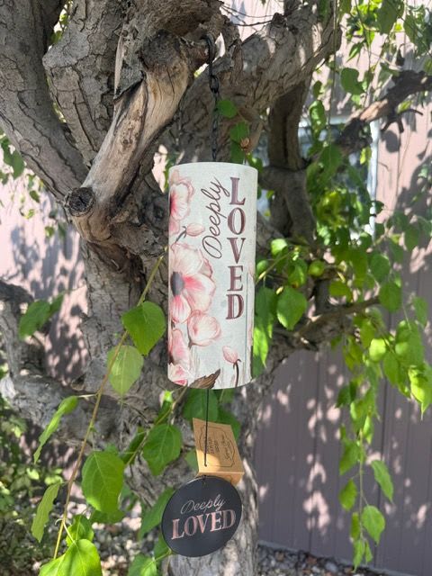 Decorative memorial sign hanging from a tree branch