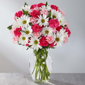 Pink and white daisy and carnation bouquet in a clear glass vase