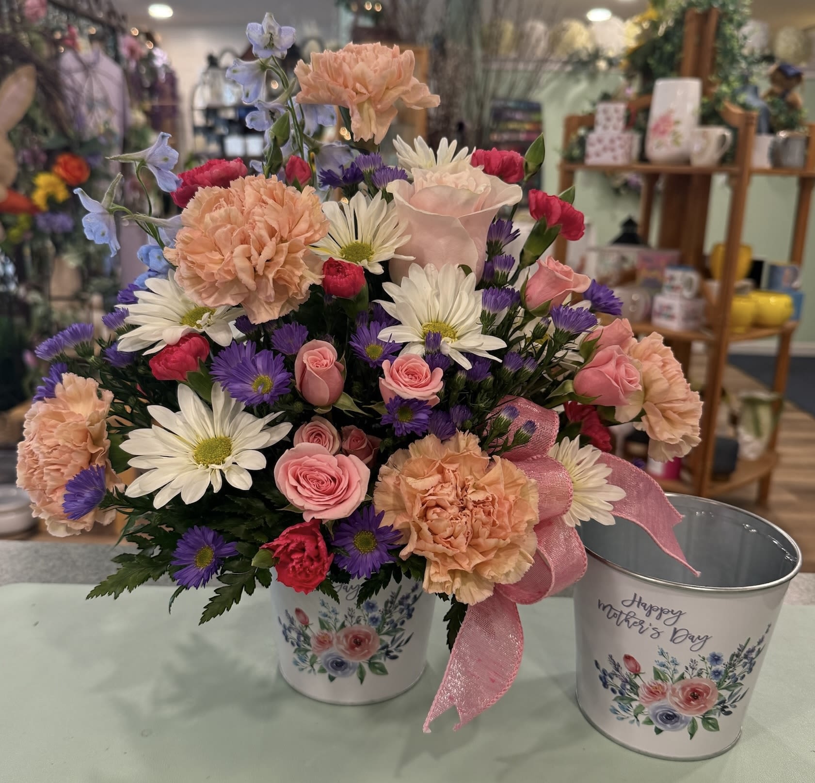 Mom's Flower Pail (MFP) - Soft pastels of peach, pink, white, blue and lavender make this flower arrangement an instantly comforting gift! Surprise the moms in your life with this charming arrangement. 