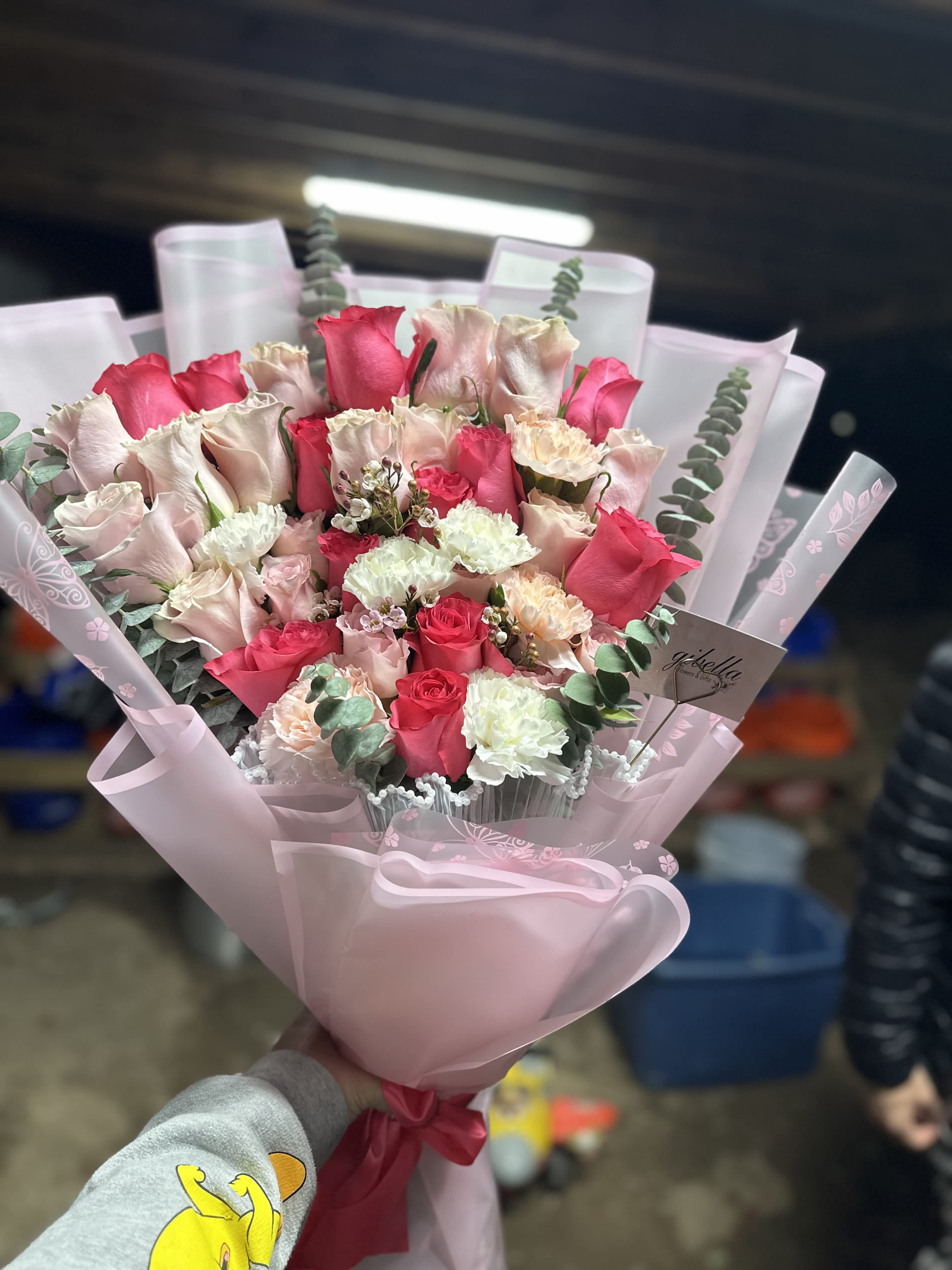 Pink and white rose bouquet wrapped in pale pink paper